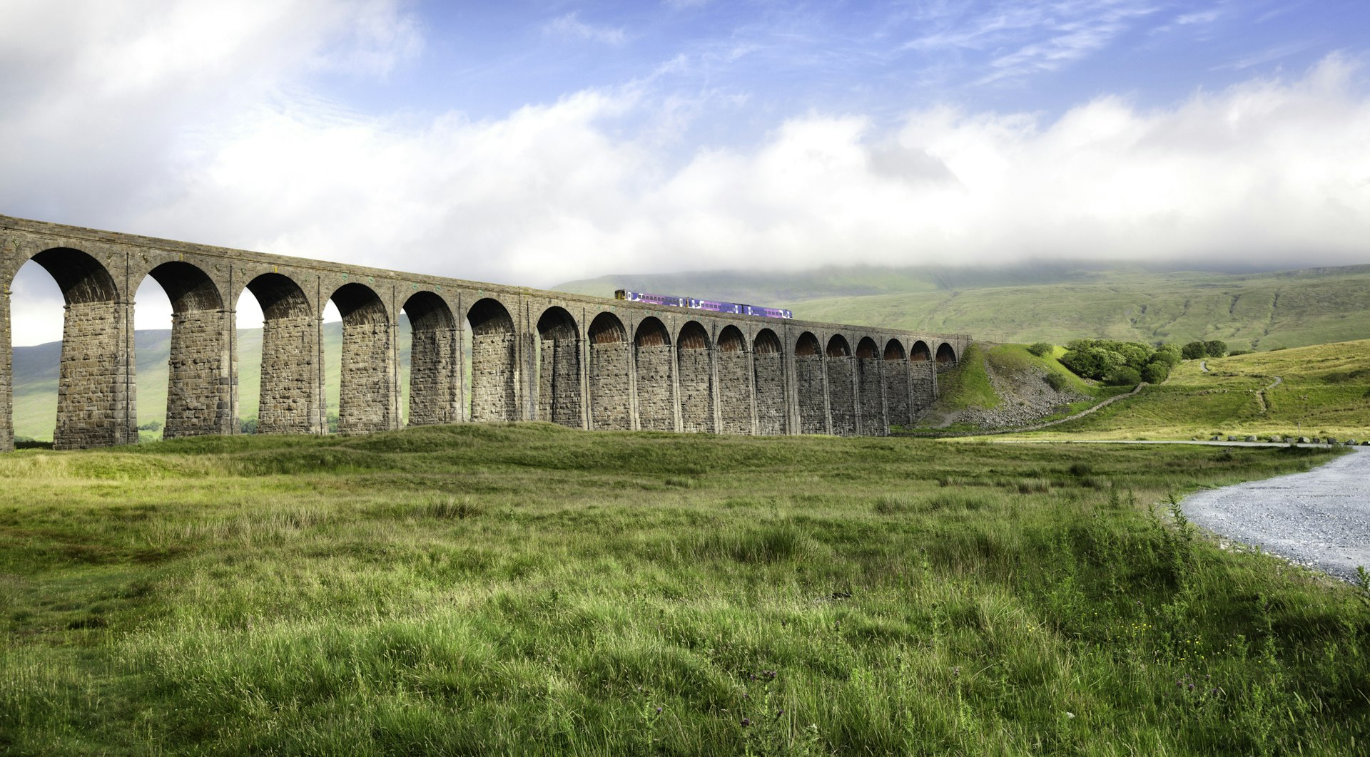Train crossing the Ribblehead viaduct in Yorkshire Dales, England.