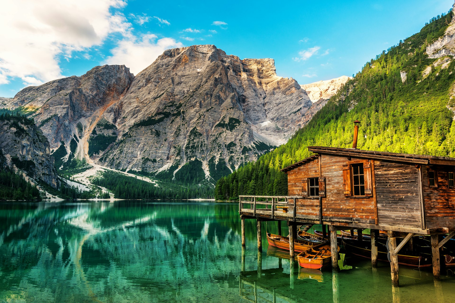 The wooden Boathouse at the Lago di Braies with the Dolomite Mountains in the background