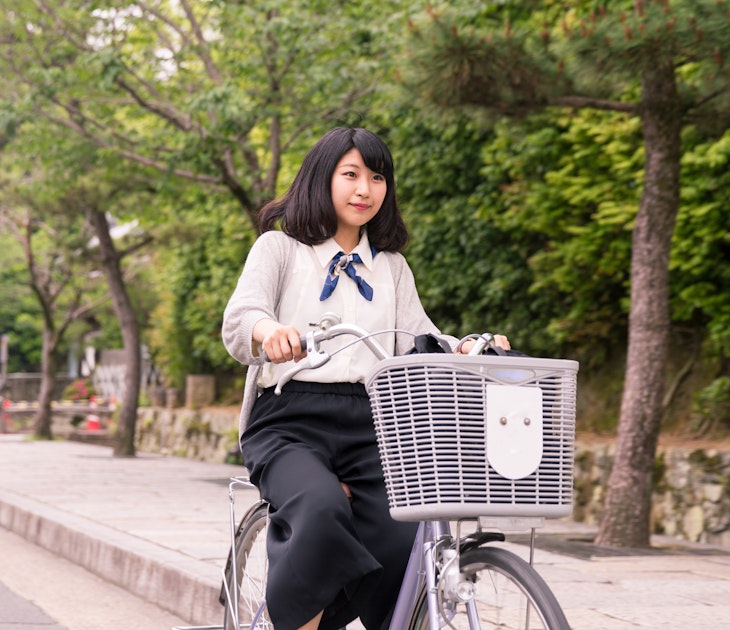 A young woman cycling through the streets of Kyoto