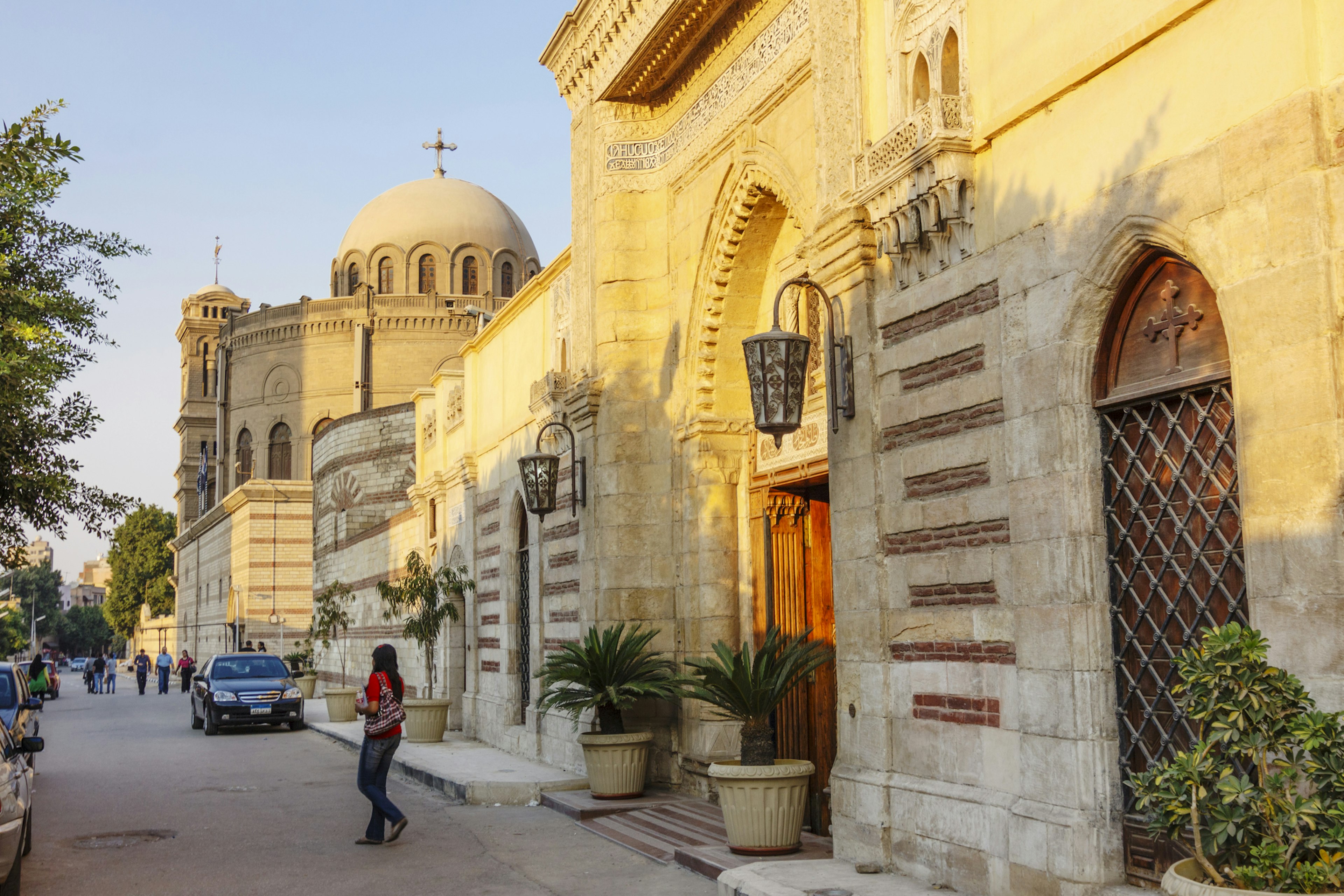 A person crosses the street outside a church with a round dome