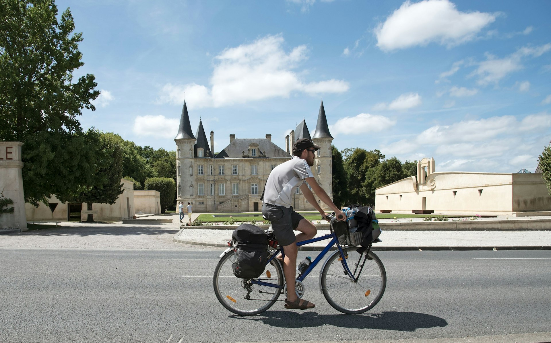  A man cycles past Château Pichon Longueville, Pauillac, Gironde, France