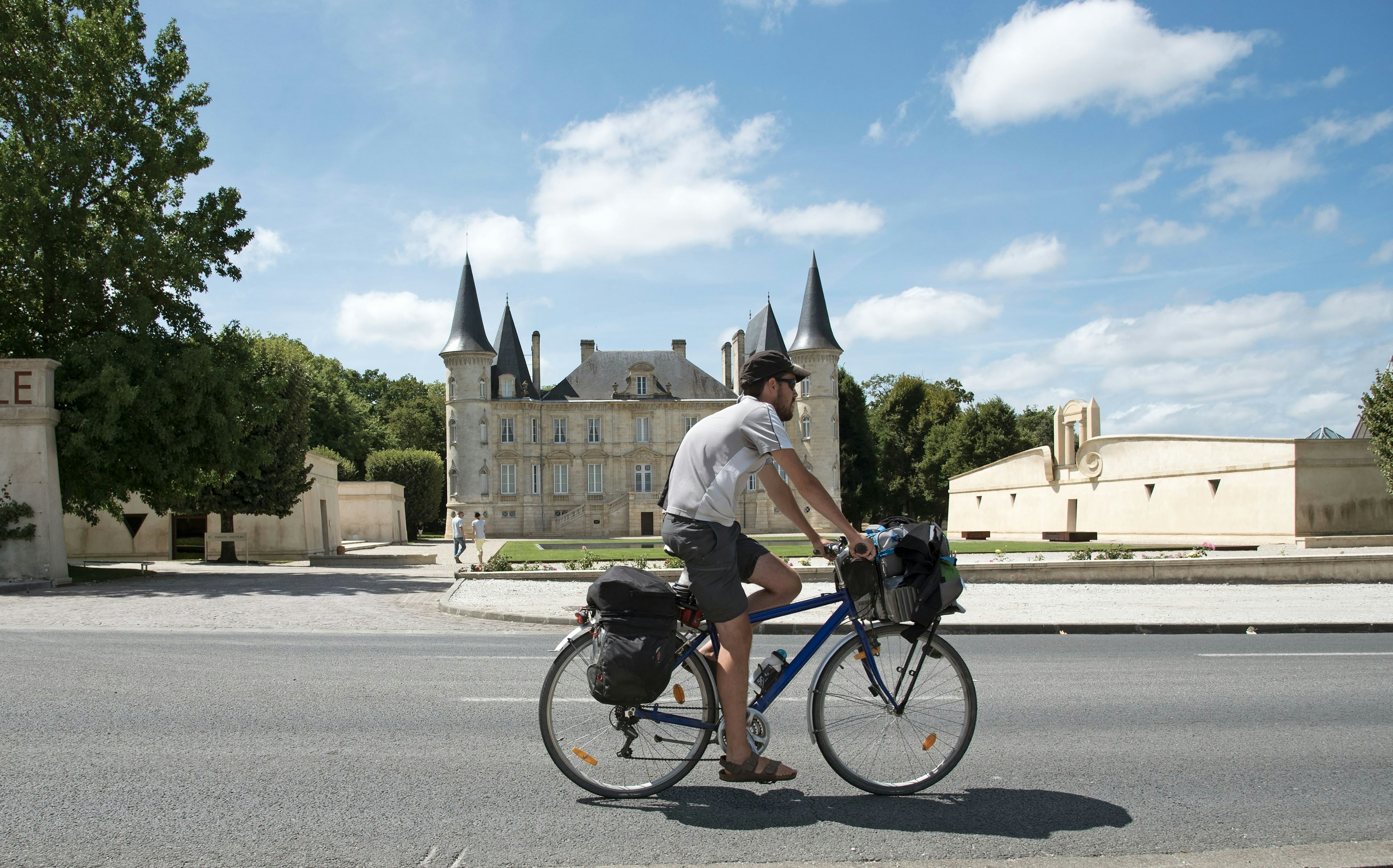 A man cycles past Château Pichon Longueville, Pauillac, Gironde, France