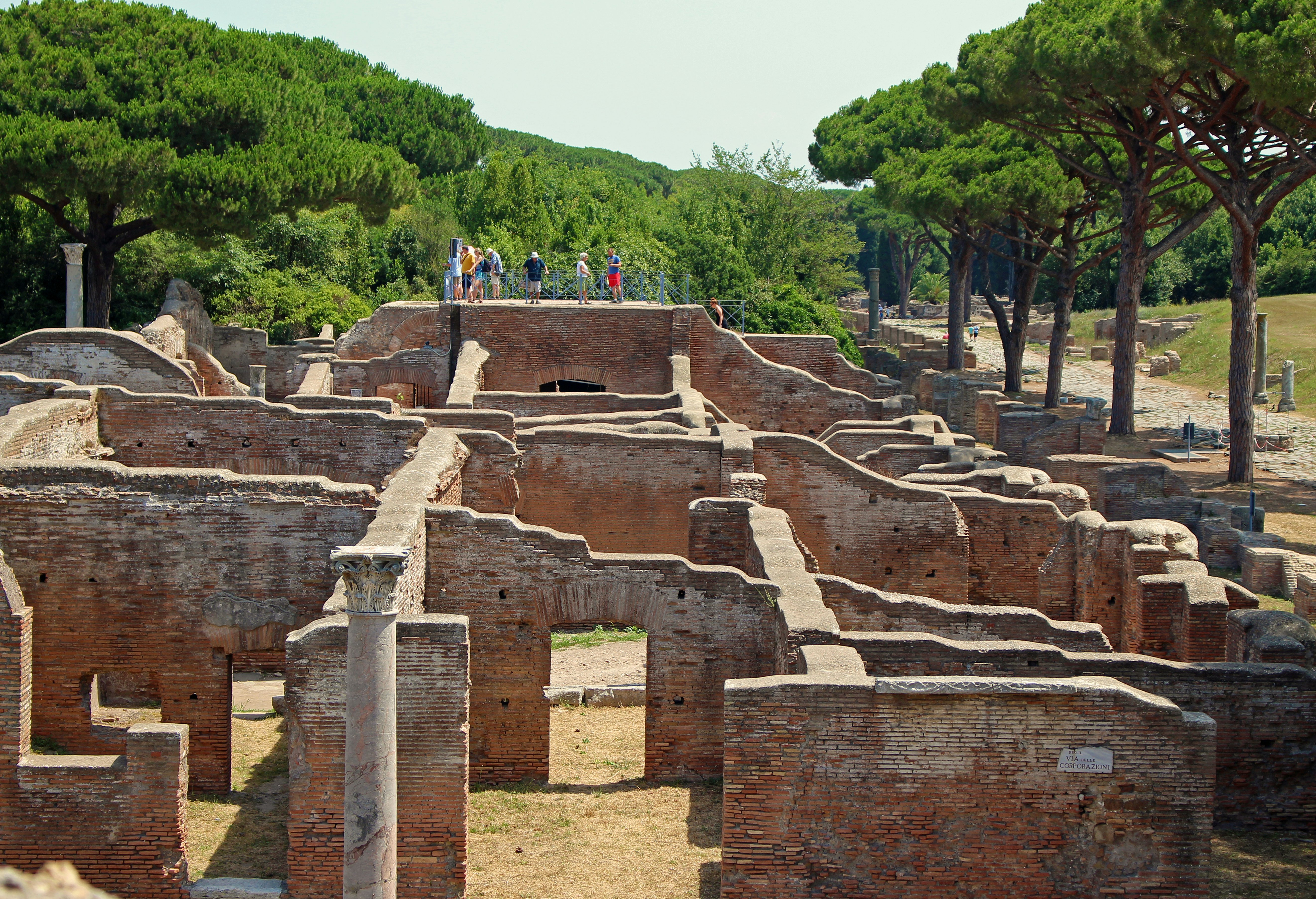 Tourists walk on a wall overlooking the Baths of Neptune to get a better view of the mosaic floors