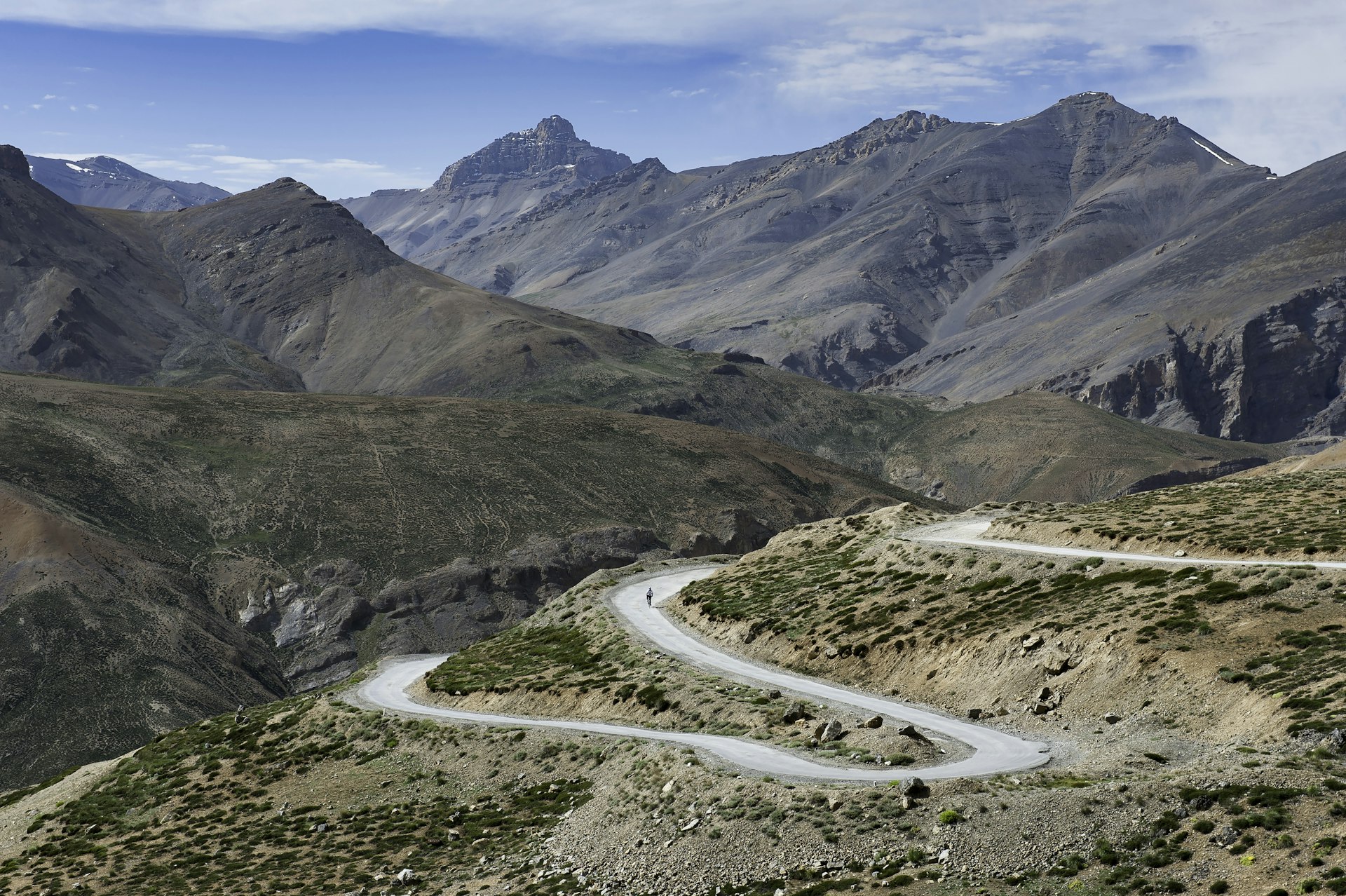 A cyclist pedals on a switchback in the mountains of Ladakh, India
