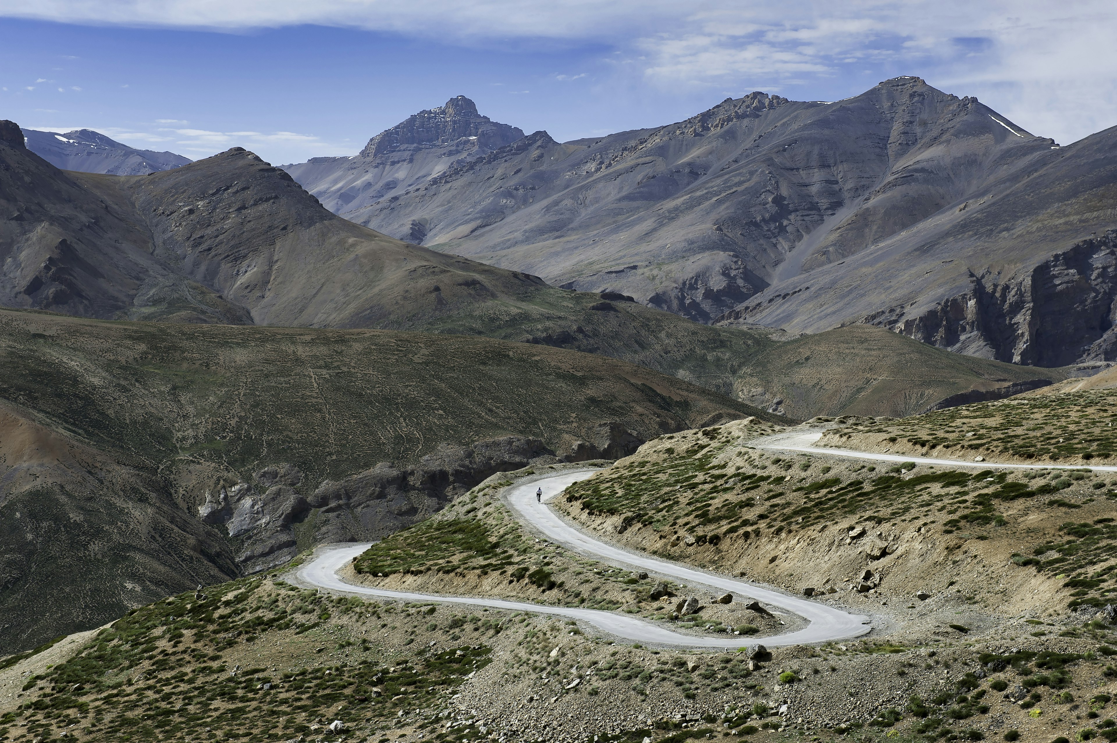 A cyclist pedals on a switchback in the mountains of Ladakh, India