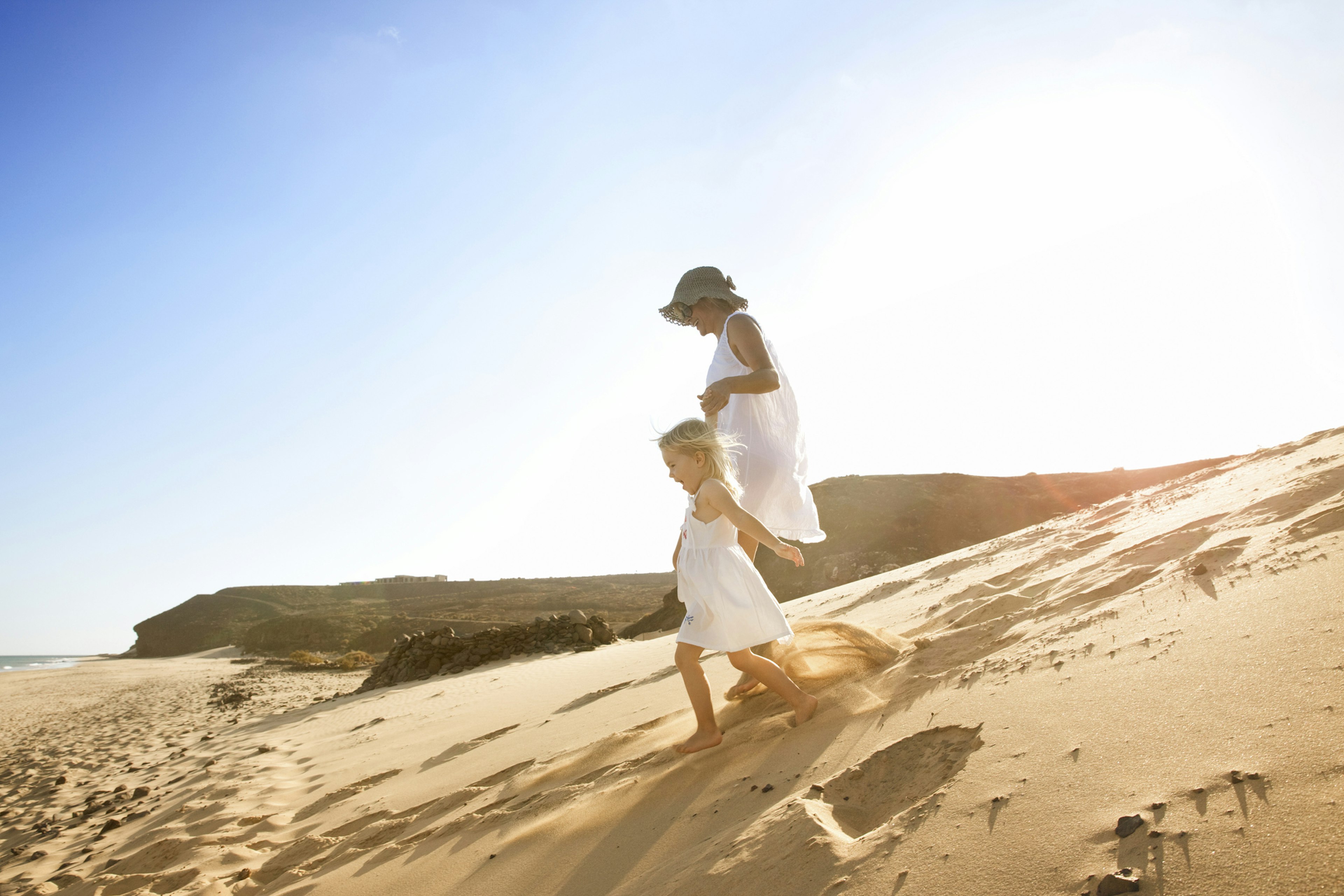 Spain, Fuerteventura, mother running with daughter on the beach