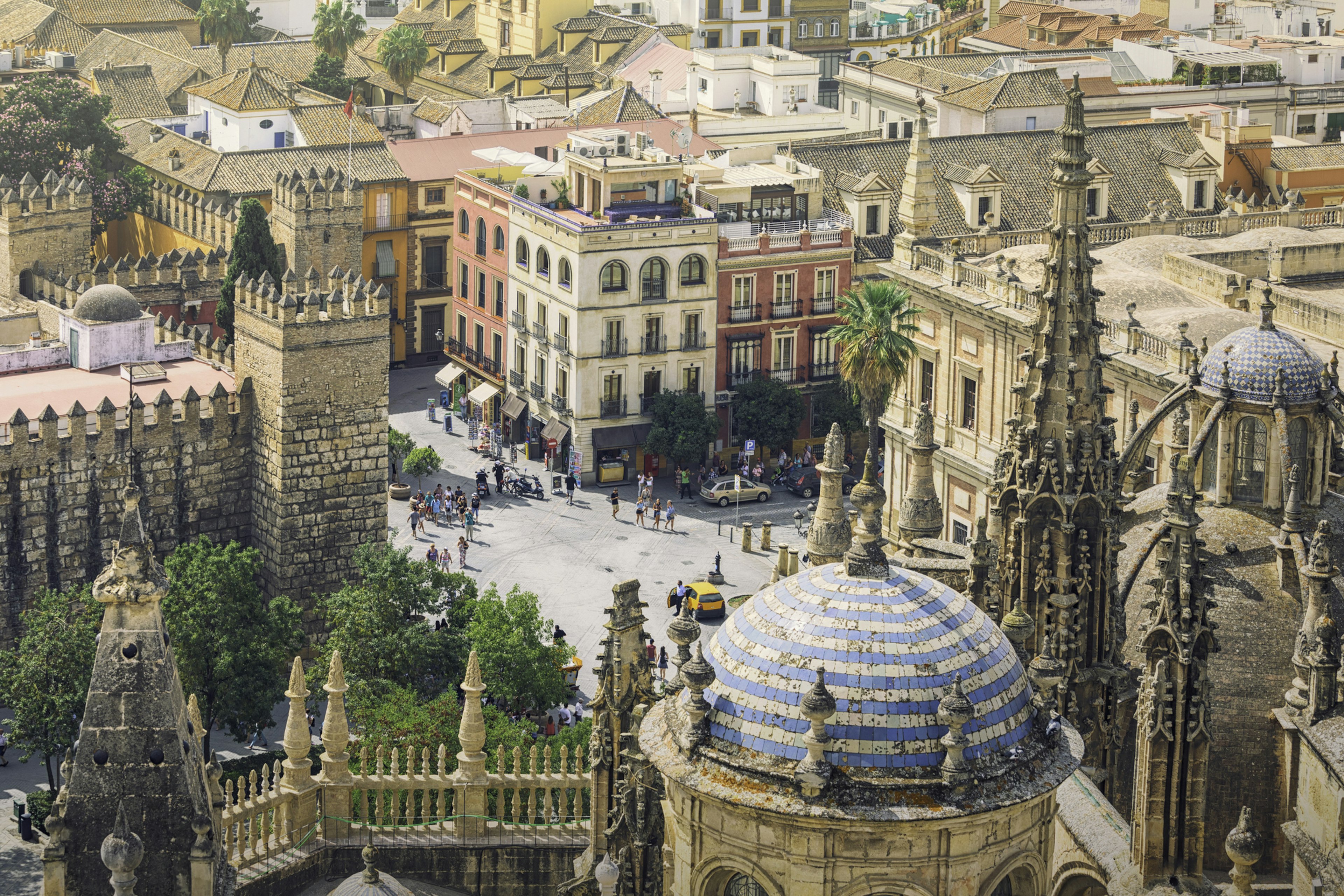 The dome and turrets of a large cathedral with a city square below