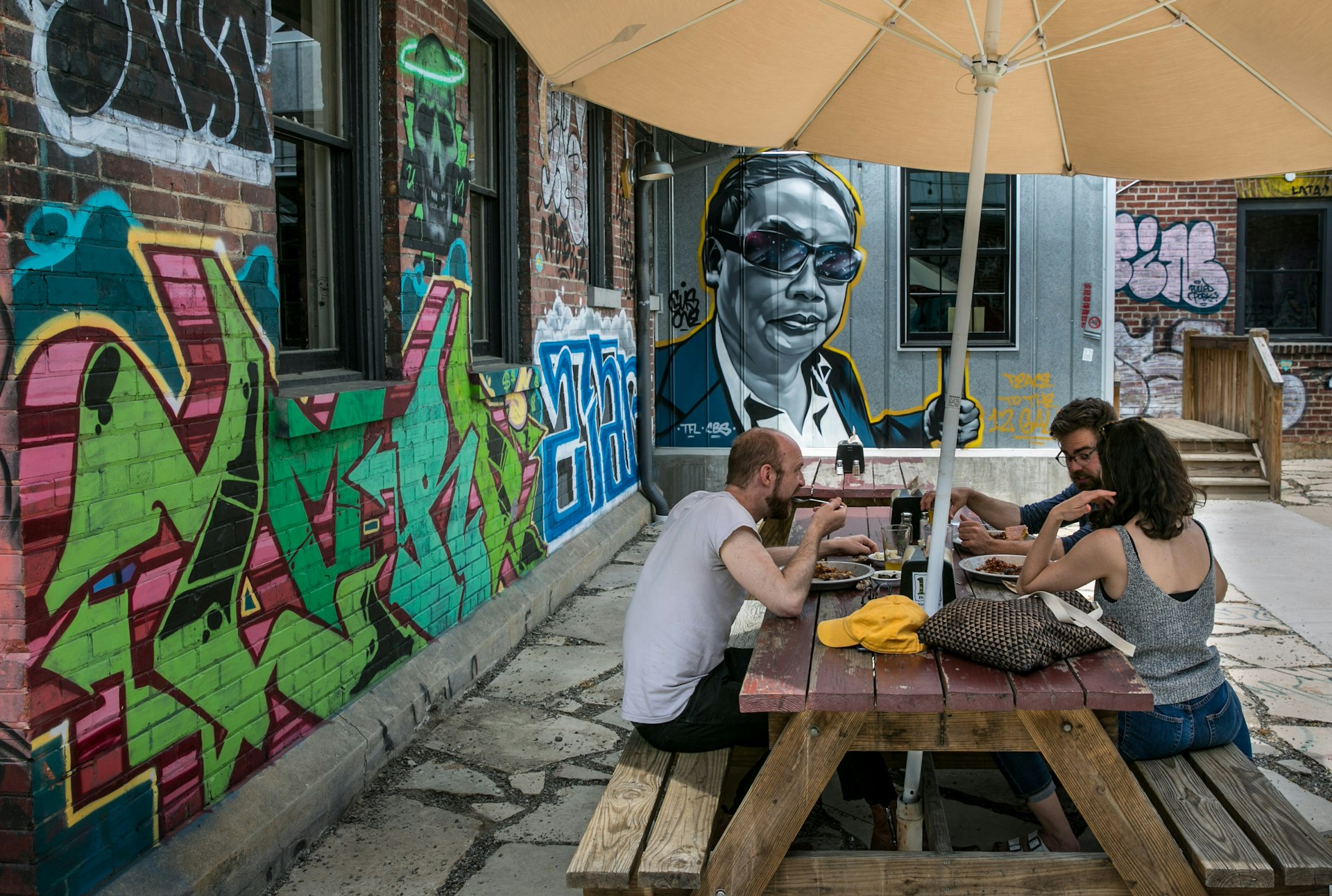 People enjoy the outside patio at 12 Bones Smokehouse barbecue restaurant in the River Arts District, Asheville, North Carolina, USA