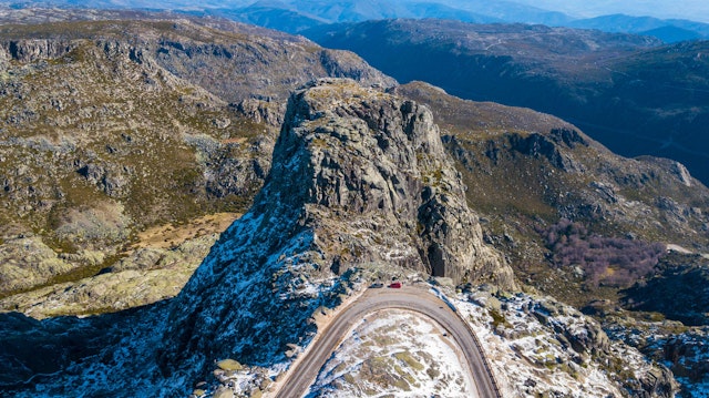 Rocky mountain pass in Serra da Estrela with cars parked on road side