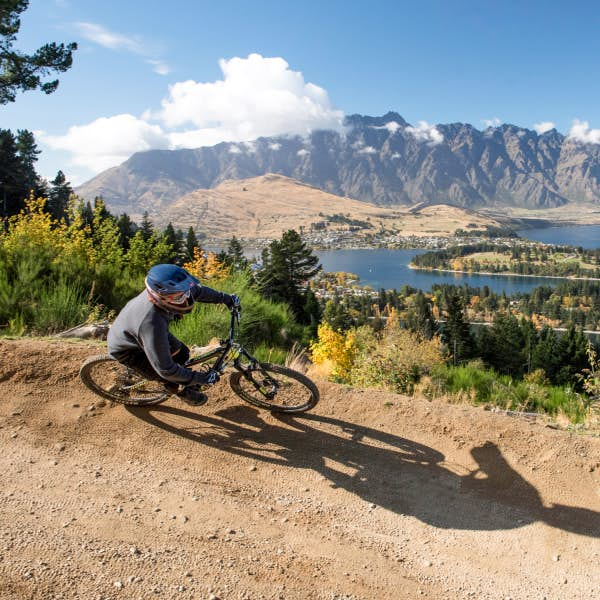 Cyclist on a trail near lakes and mountains