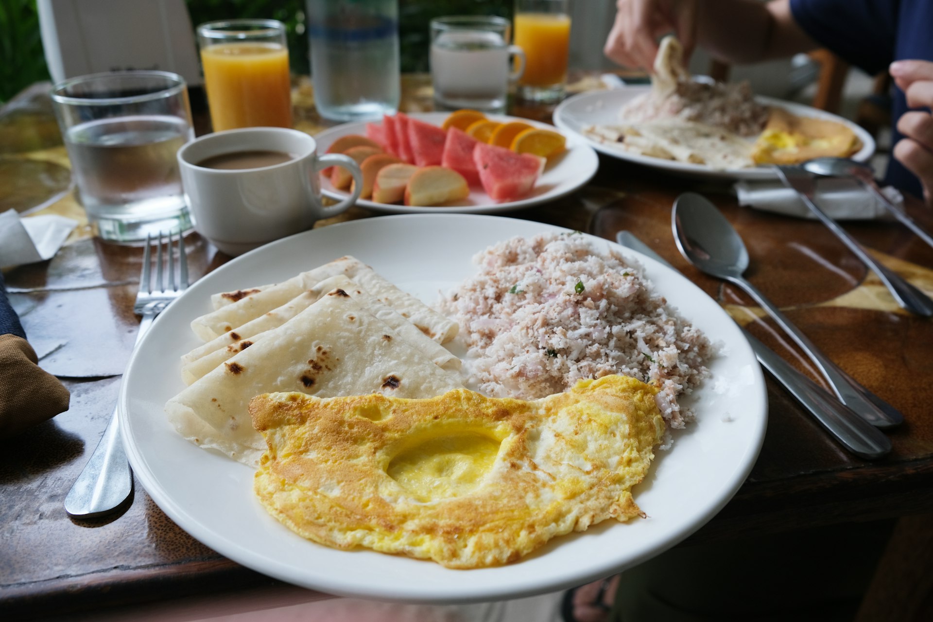 A plate of food being served in a restaurant in the Maldives which includes an omelet and rice