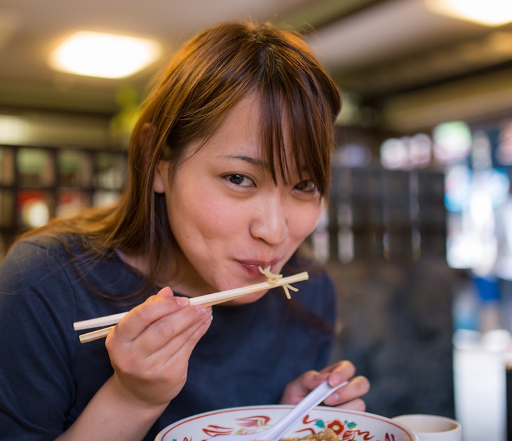 Young woman eating ramen noodle in old Japanese restaurant