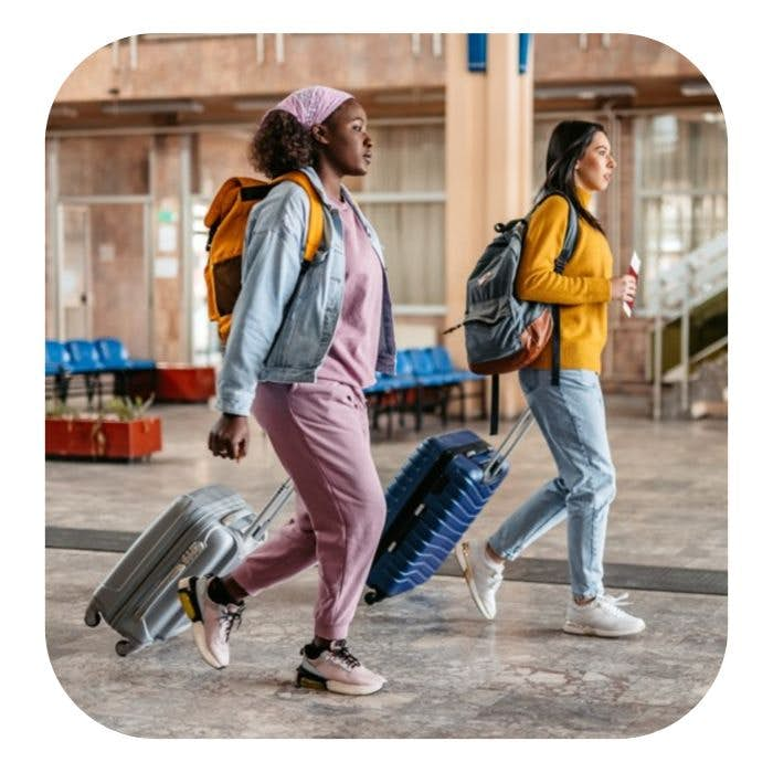 Women walking through the airport with luggage