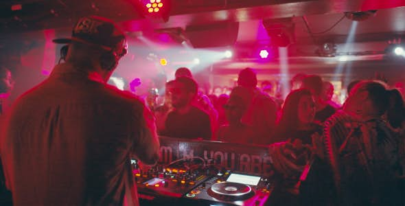 DJ in a club in Nairobi with pink lights shining on a crowd of people