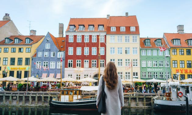 Woman looking at colorful buildings in Copenhagen.