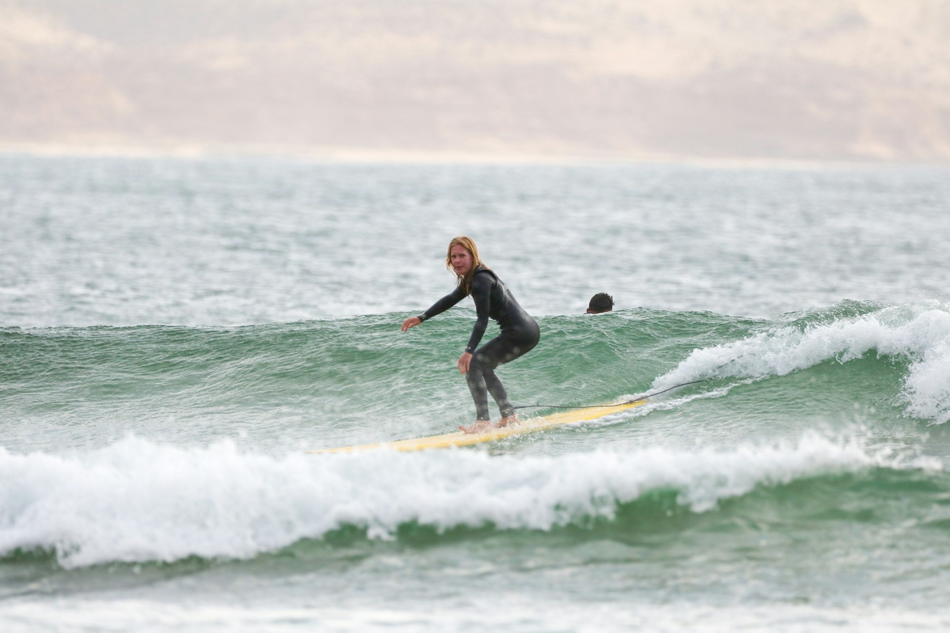 Sally Kirby rides a wave on a longboard in Imsouane, Morocco