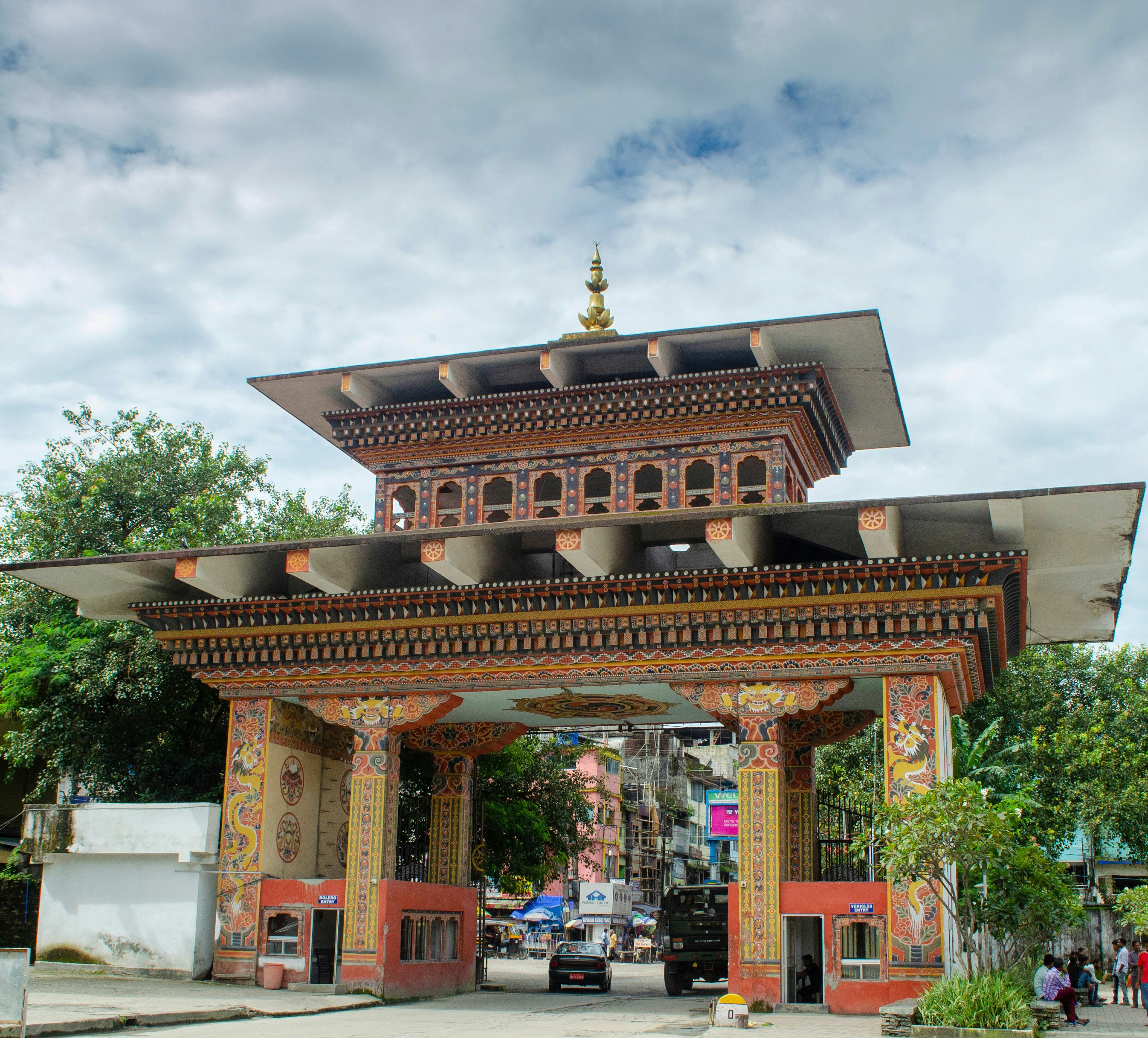 Vehicles of the Bhutanese transport company cross the Indo-Bhutan border gate, covered with dragon paintings