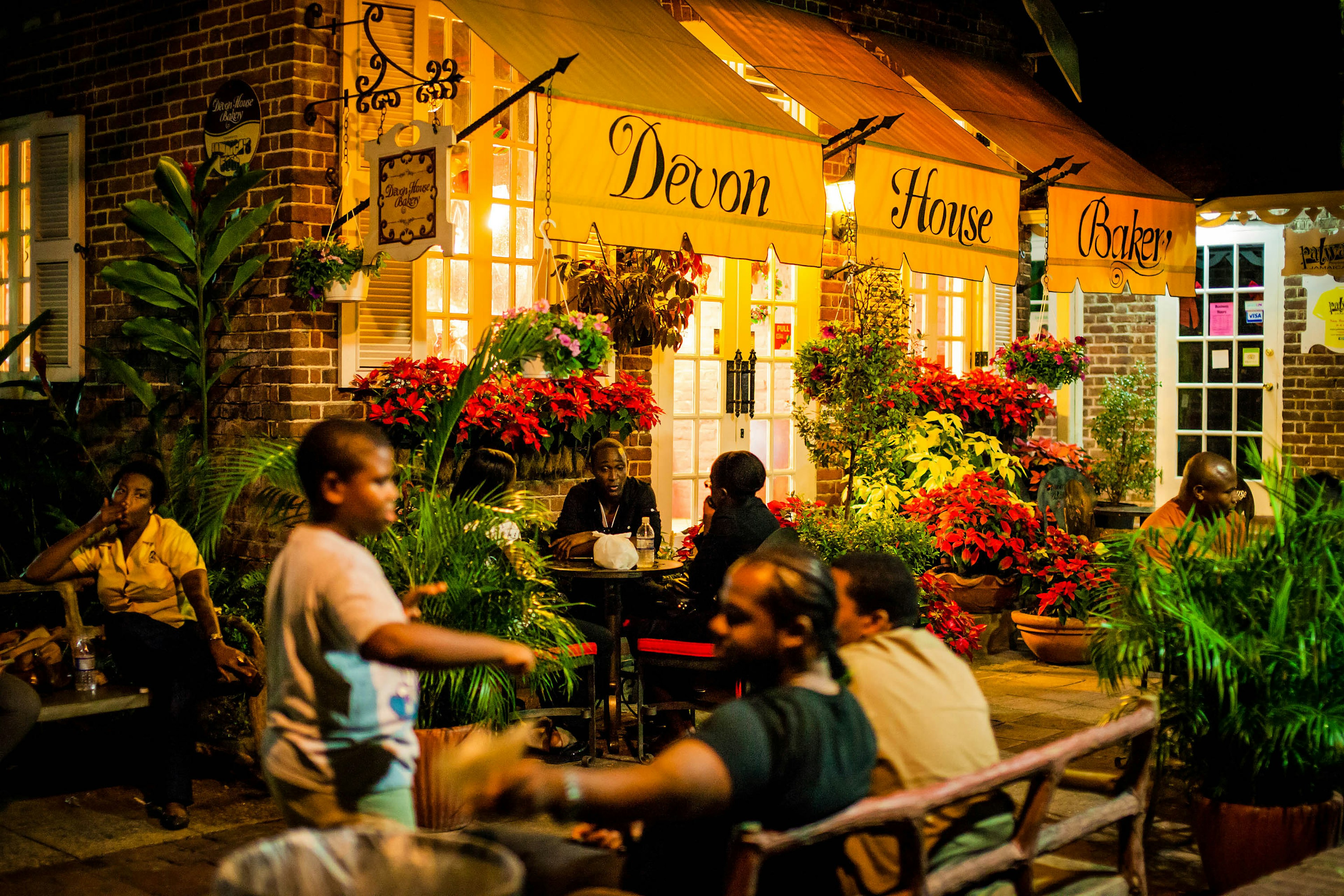 People sit outside Devon House Bakery at night