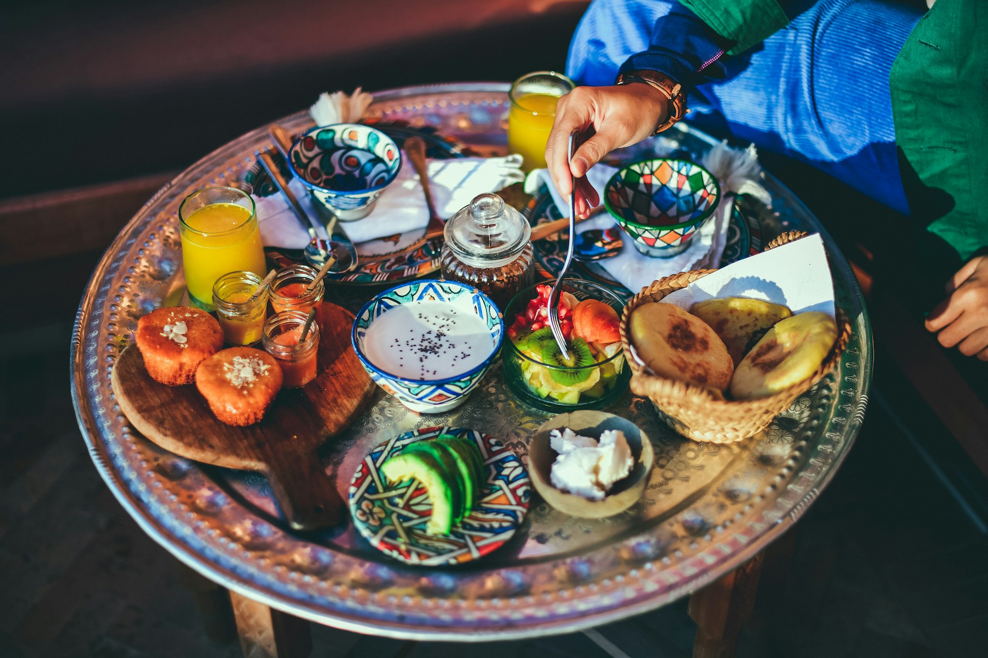 A breakfast spread in Morocco, with fresh juice, fruit, muffins, honey, yogurt and avocado