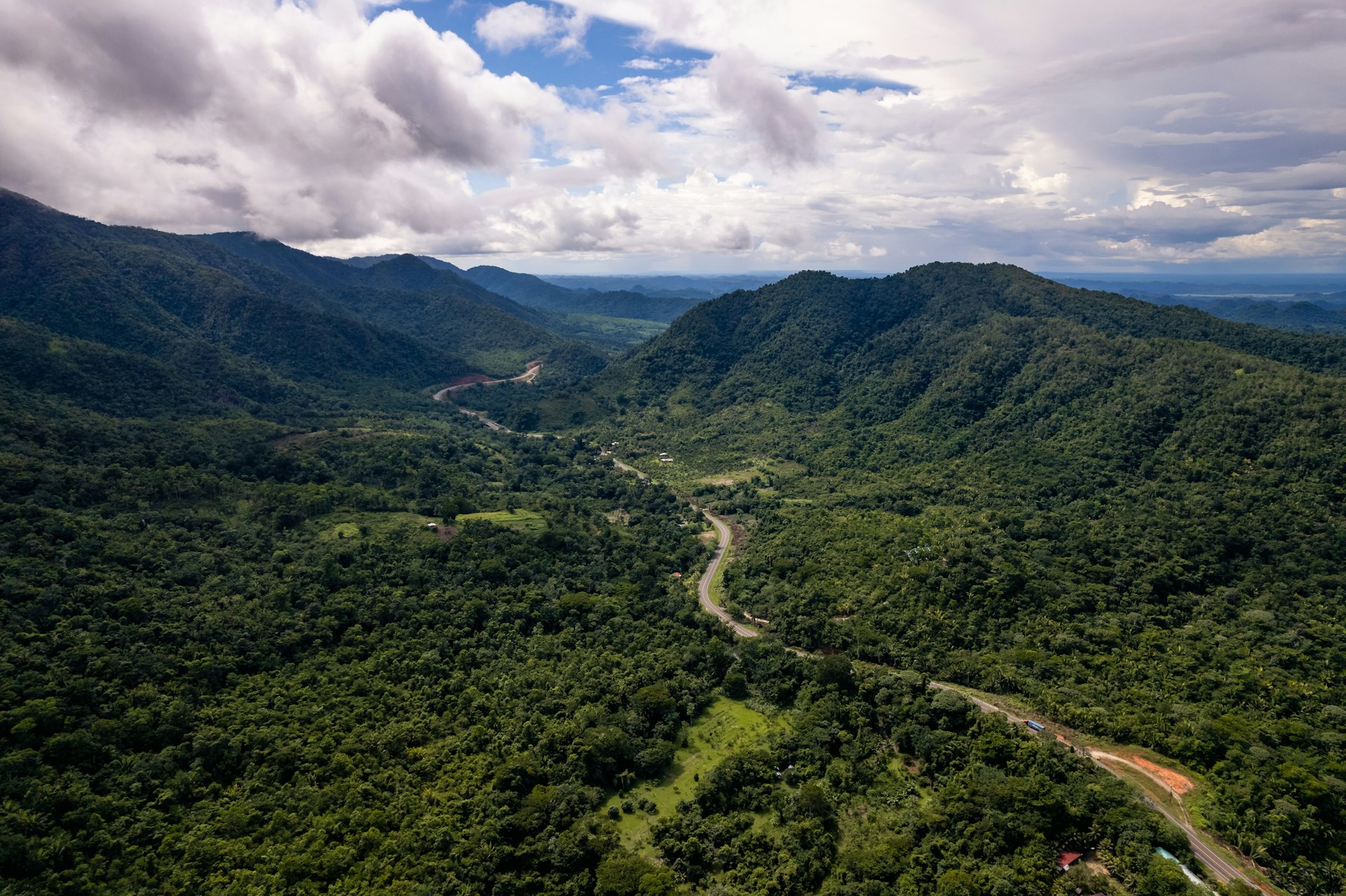 Drone photo of a valley along the Hummingbird Highway in Belize with a cloudy sky.