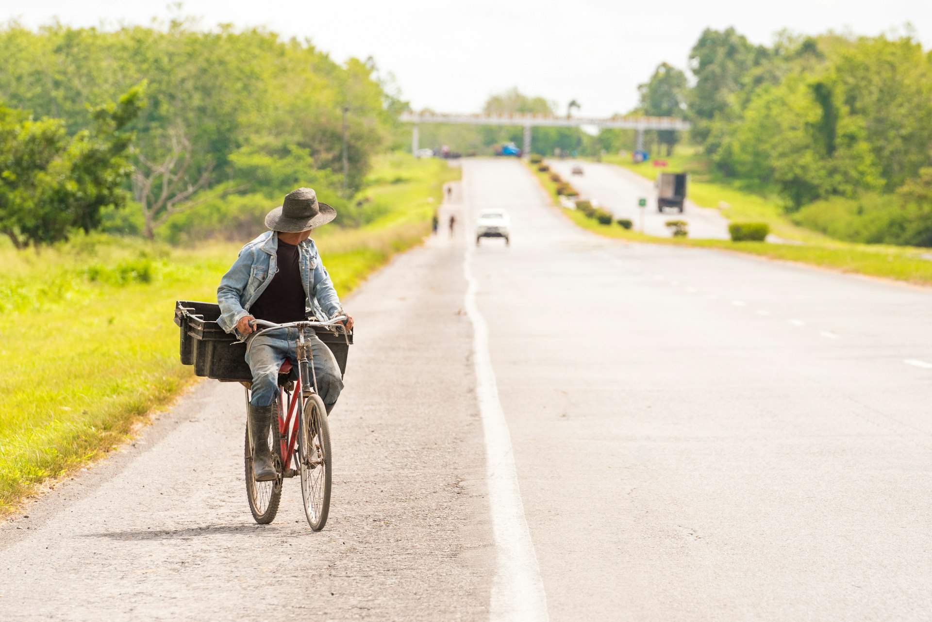 A man rides a bicycle along a highway in Viñales, Pinar del Rio, Cuba