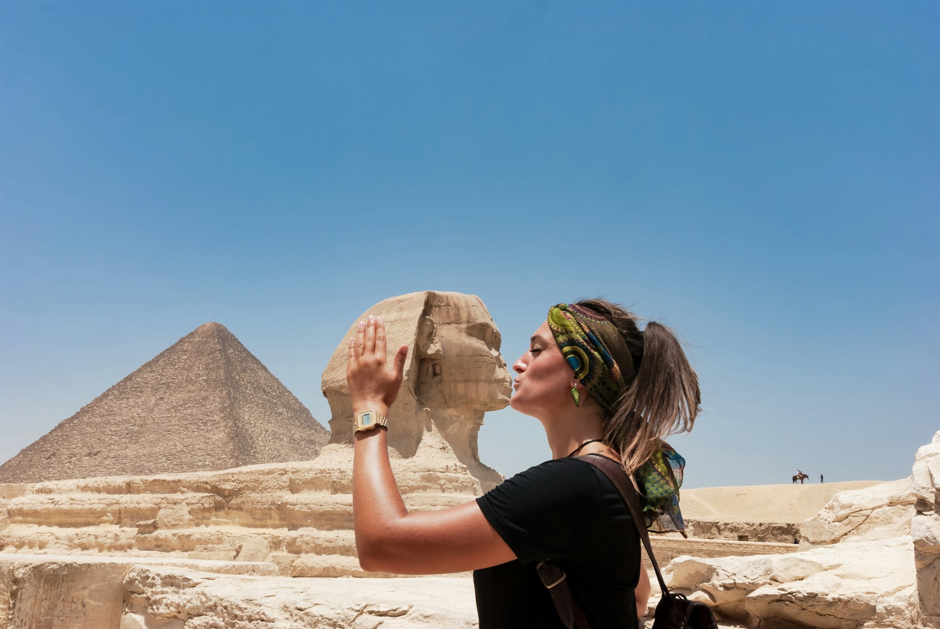 A woman pretends to kiss the Sphinx for a photograph based on a perspective trick