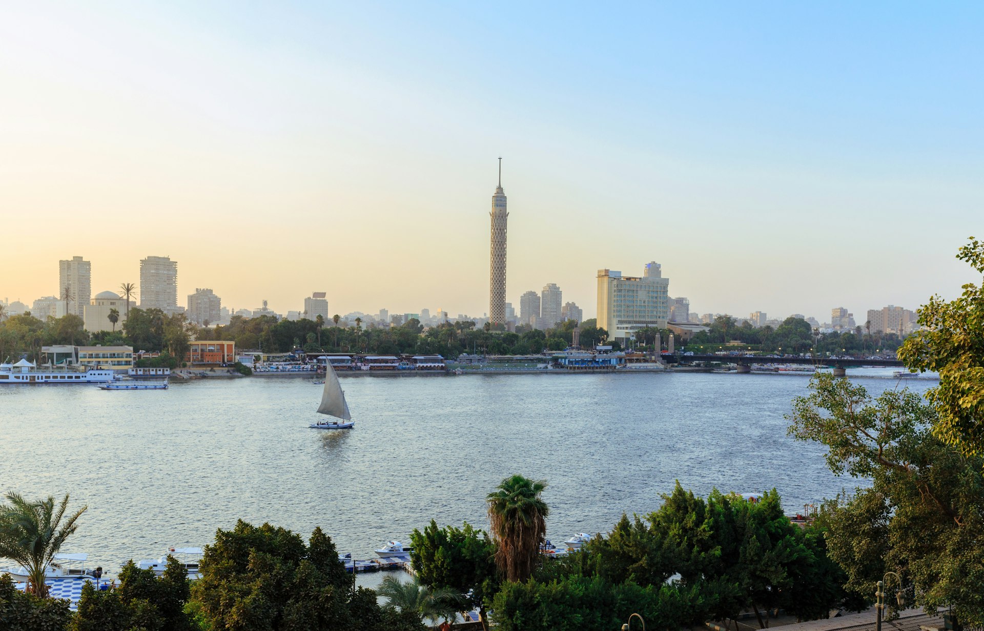The Nile River weaving through the city of Cairo, with a few small sail boats