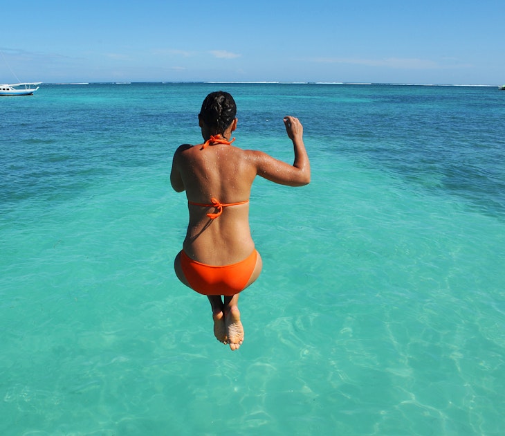 BELIZE - NOVEMBER 2016: A woman jumps off a dock and into the Caribbean Sea in San Pedro, Belize. ; Shutterstock ID 517065442; full: 65050; gl: Online Editorial; netsuite: Things to know Belize; your: Bailey Freeman
517065442