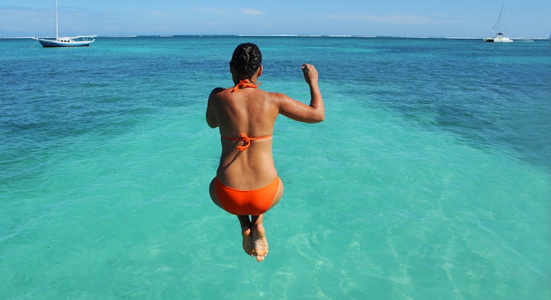 BELIZE - NOVEMBER 2016: A woman jumps off a dock and into the Caribbean Sea in San Pedro, Belize. ; Shutterstock ID 517065442; full: 65050; gl: Online Editorial; netsuite: Things to know Belize; your: Bailey Freeman
517065442