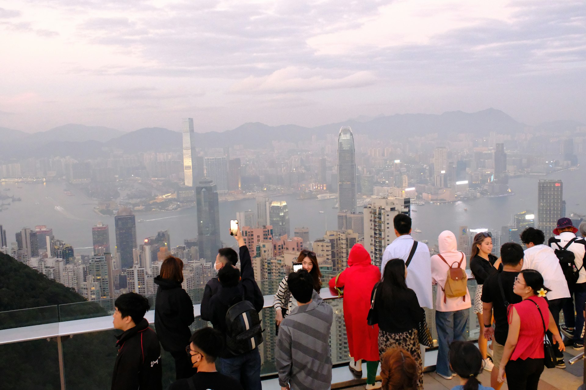 A crowd looking out over a cityscape with an overcast sky