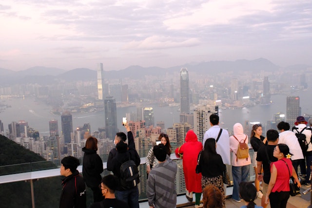 A crowd looking out over a cityscape with an overcast sky