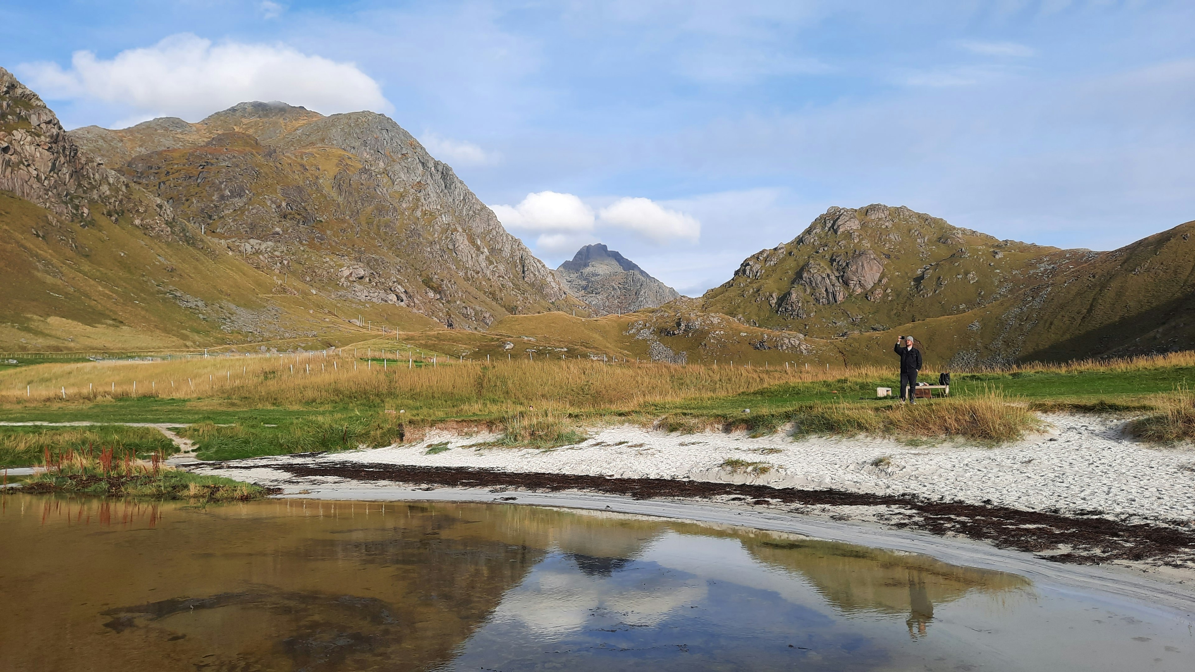 Daniel takes a photo on the sandy shores of Haukland Beach