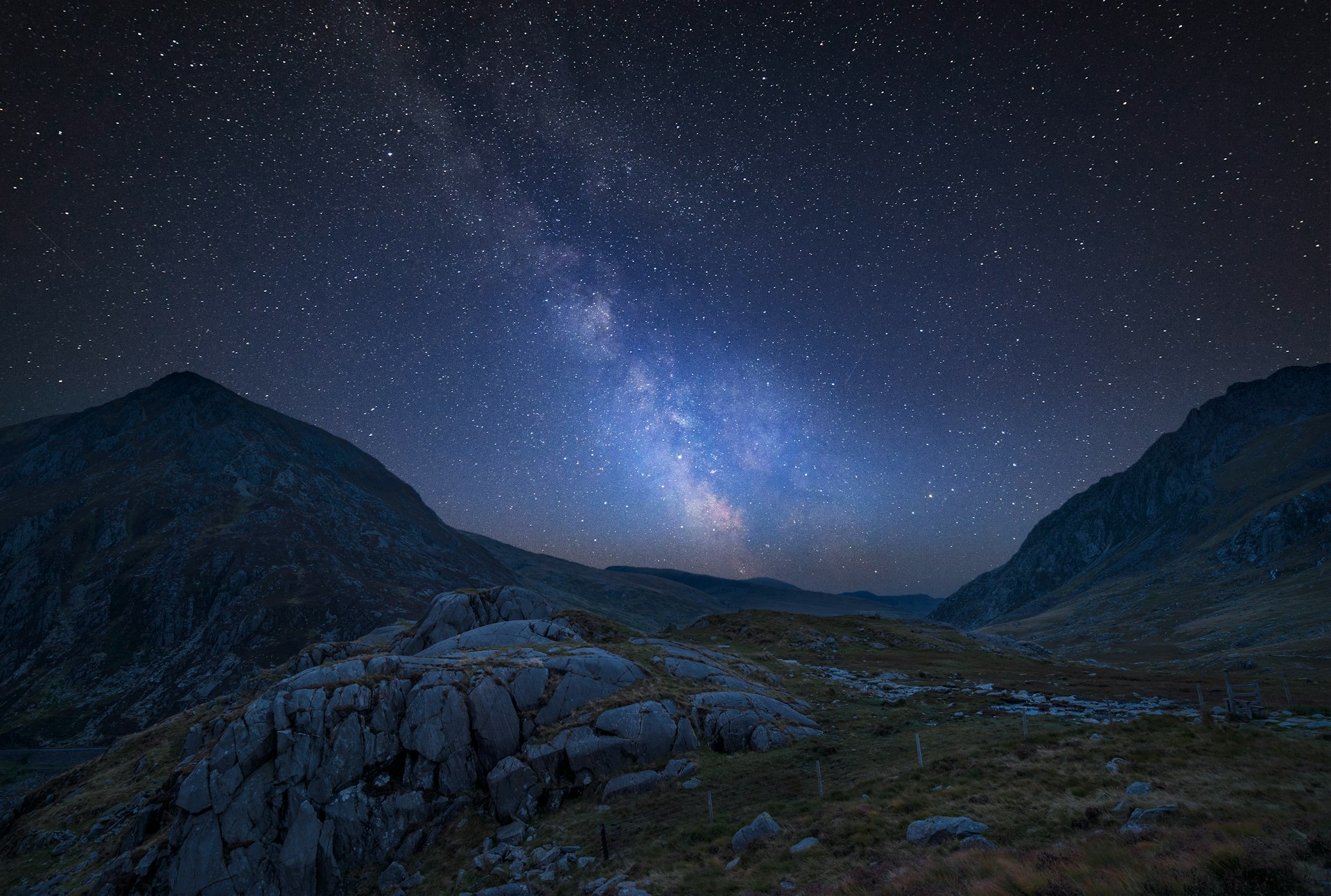 Impressionante imagem composta vibrante da Via Láctea sobre uma bela imagem de paisagem temperamental de um vale no País de Gales