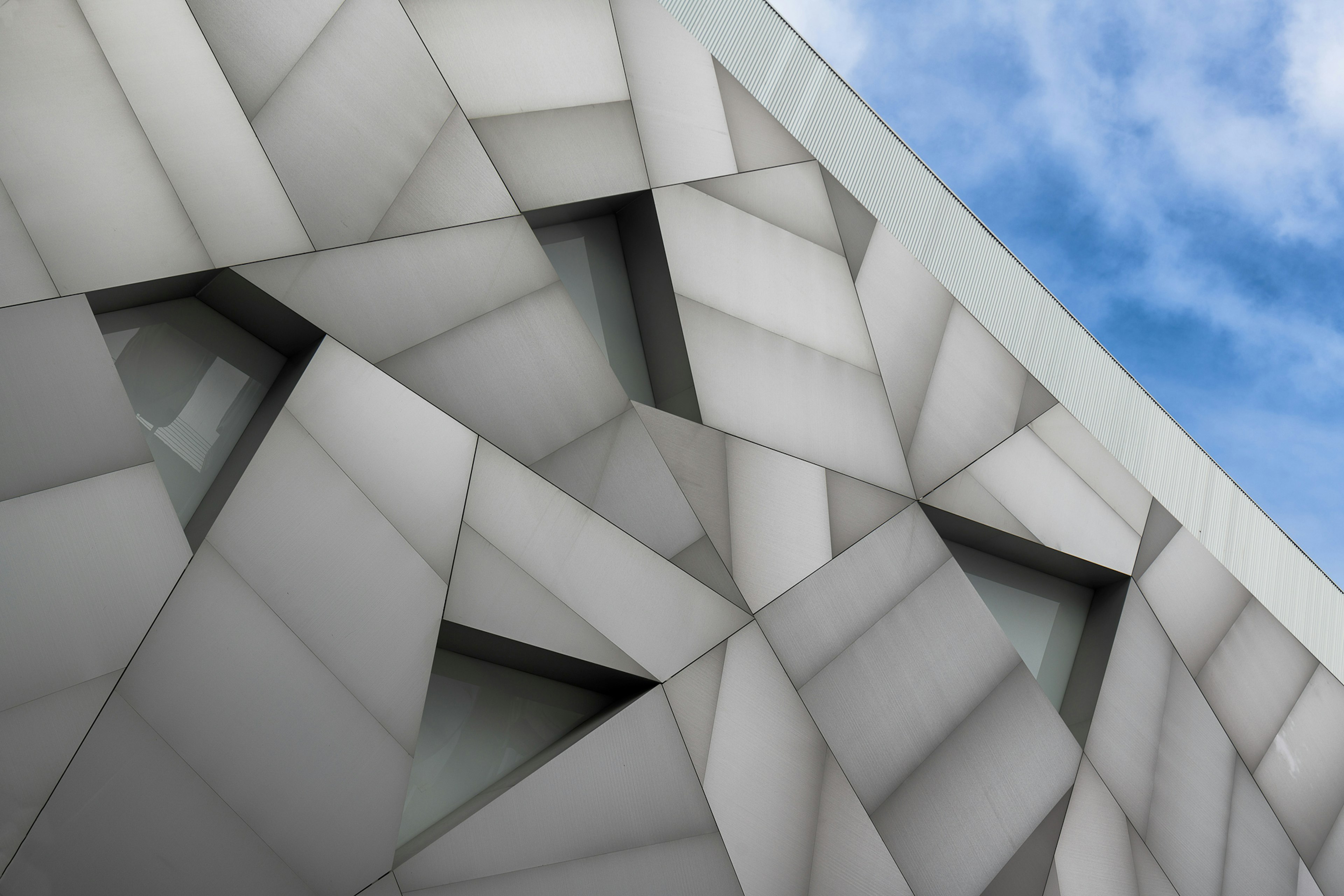 The geometric brickwork on the exterior of a museum building with triangular windows