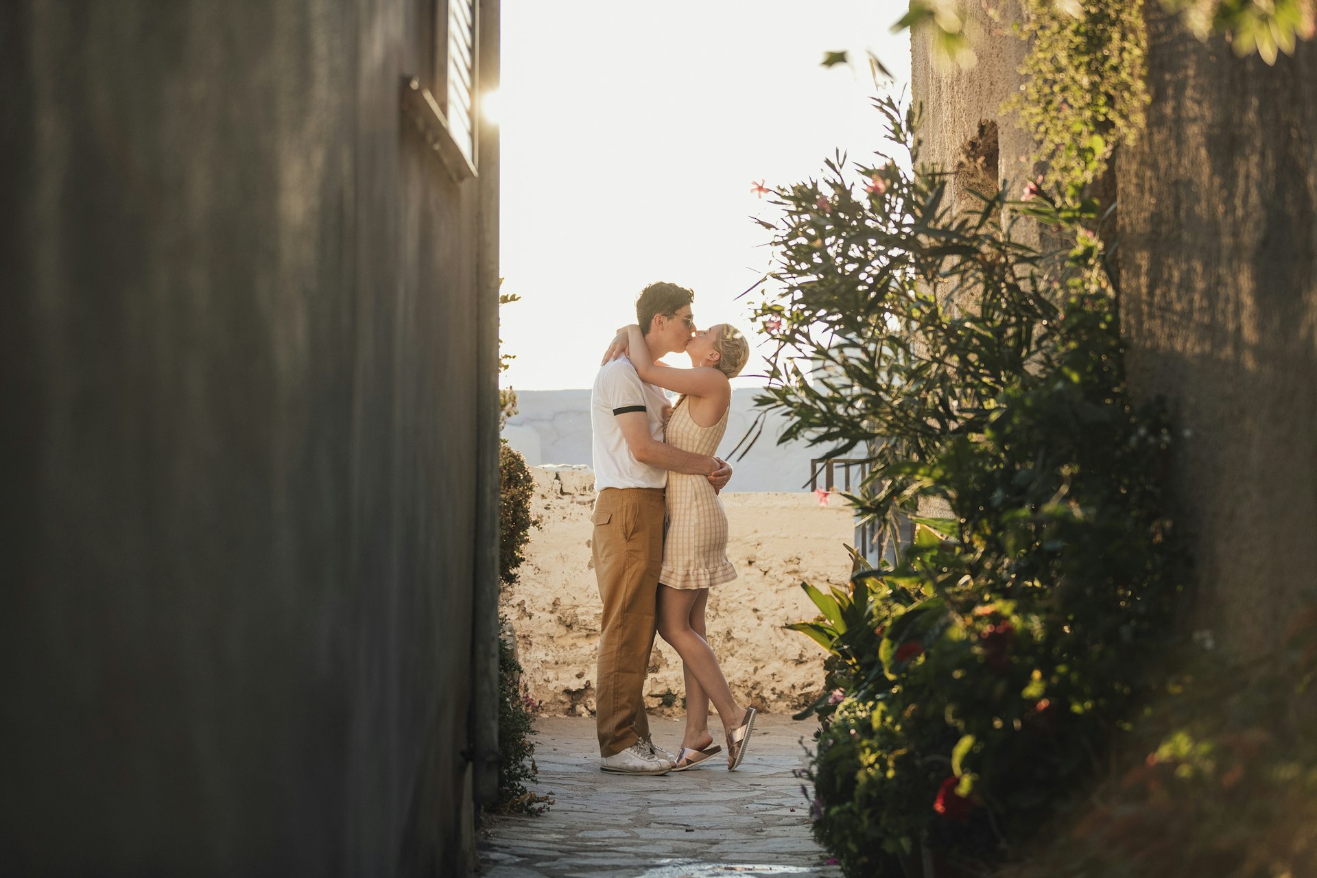 Couple in love on Mediterranean holiday, happiness, affection, carefree kiss down alleywayt 