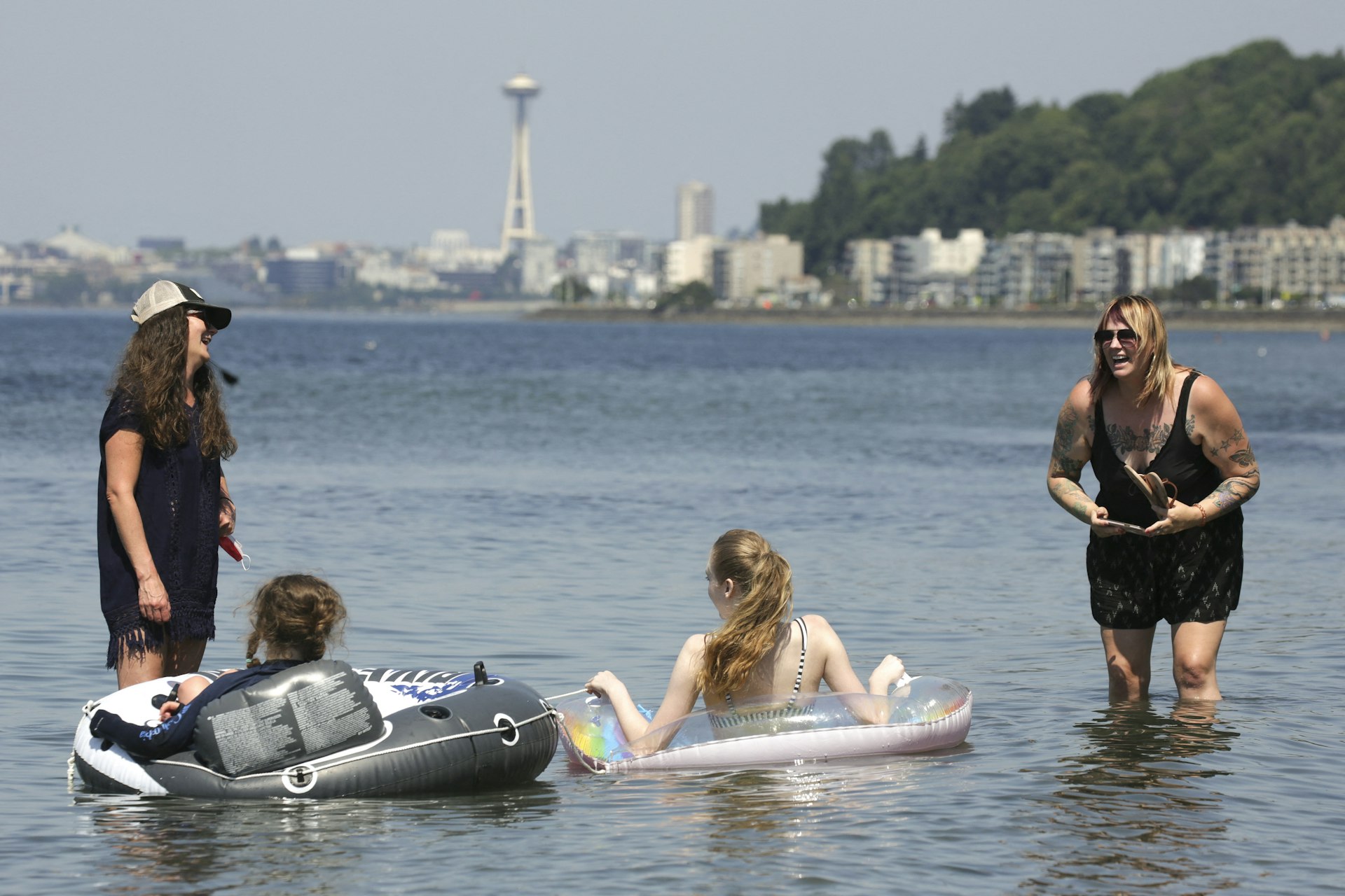 People in the water with the skyline in the distance at Alki Beach, Seattle, Washington, USA