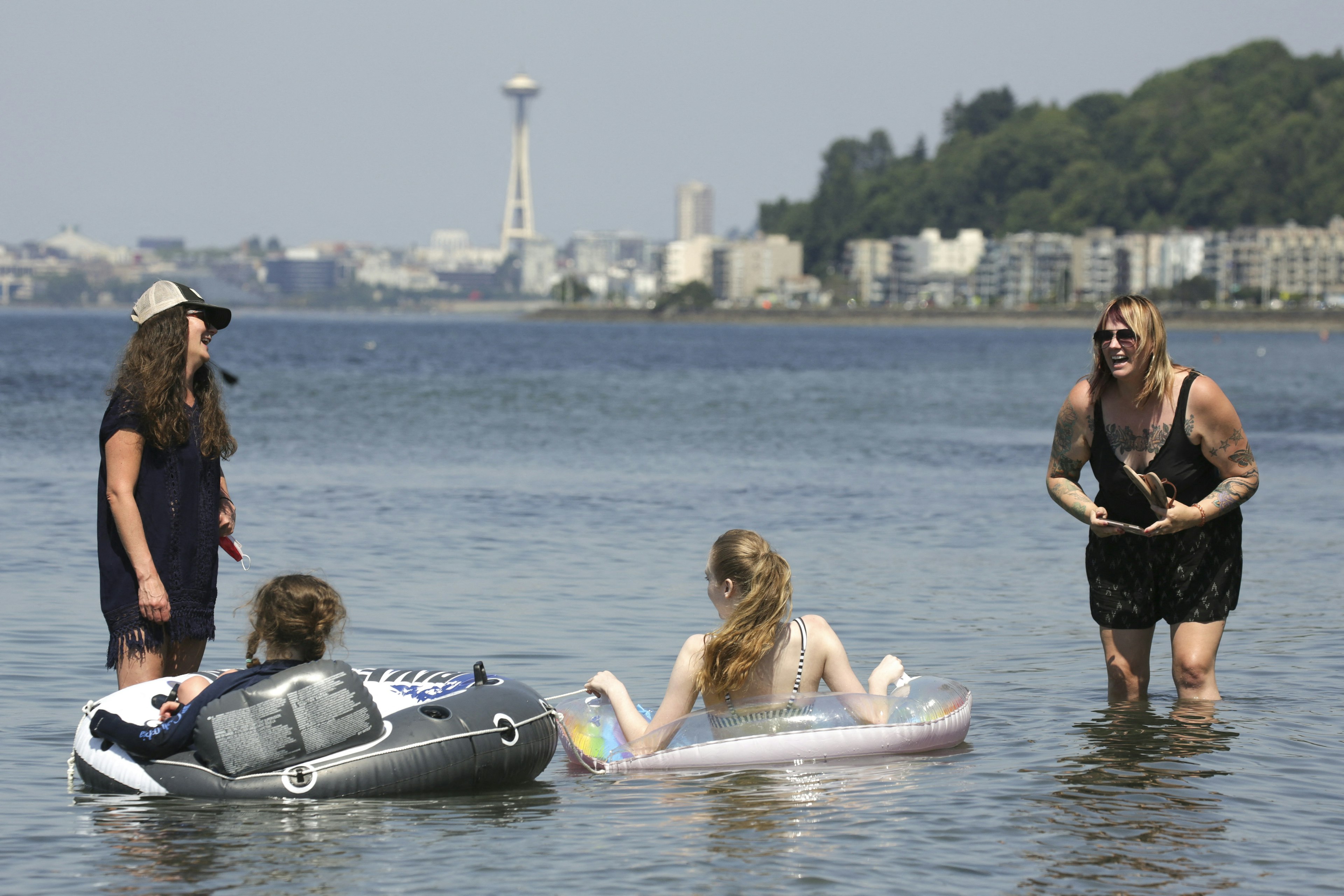 People in the water with the skyline in the distance at Alki Beach, Seattle