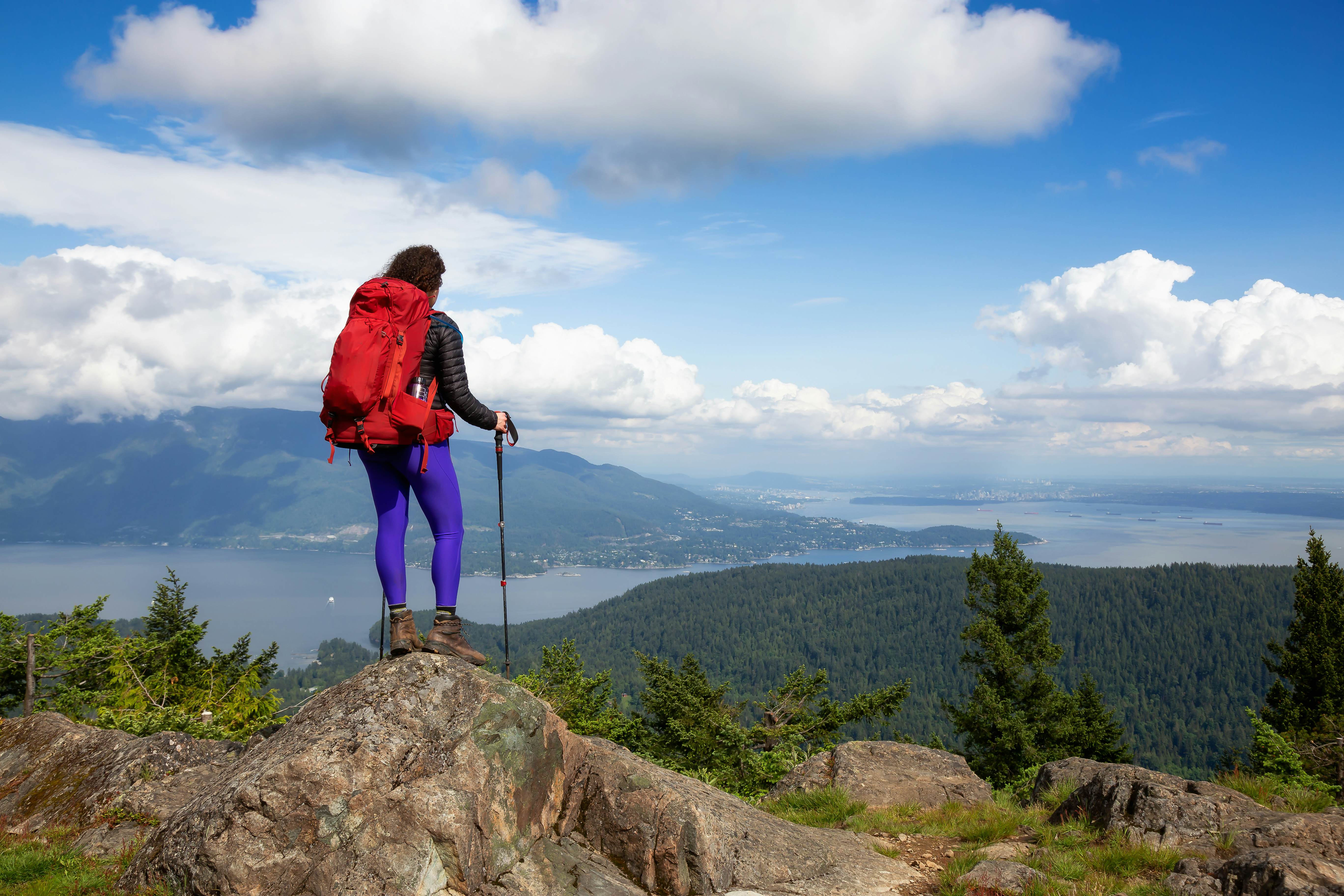 A hiker on a hilltop overlooking the water, Bowen Island, British Columbia, Canada