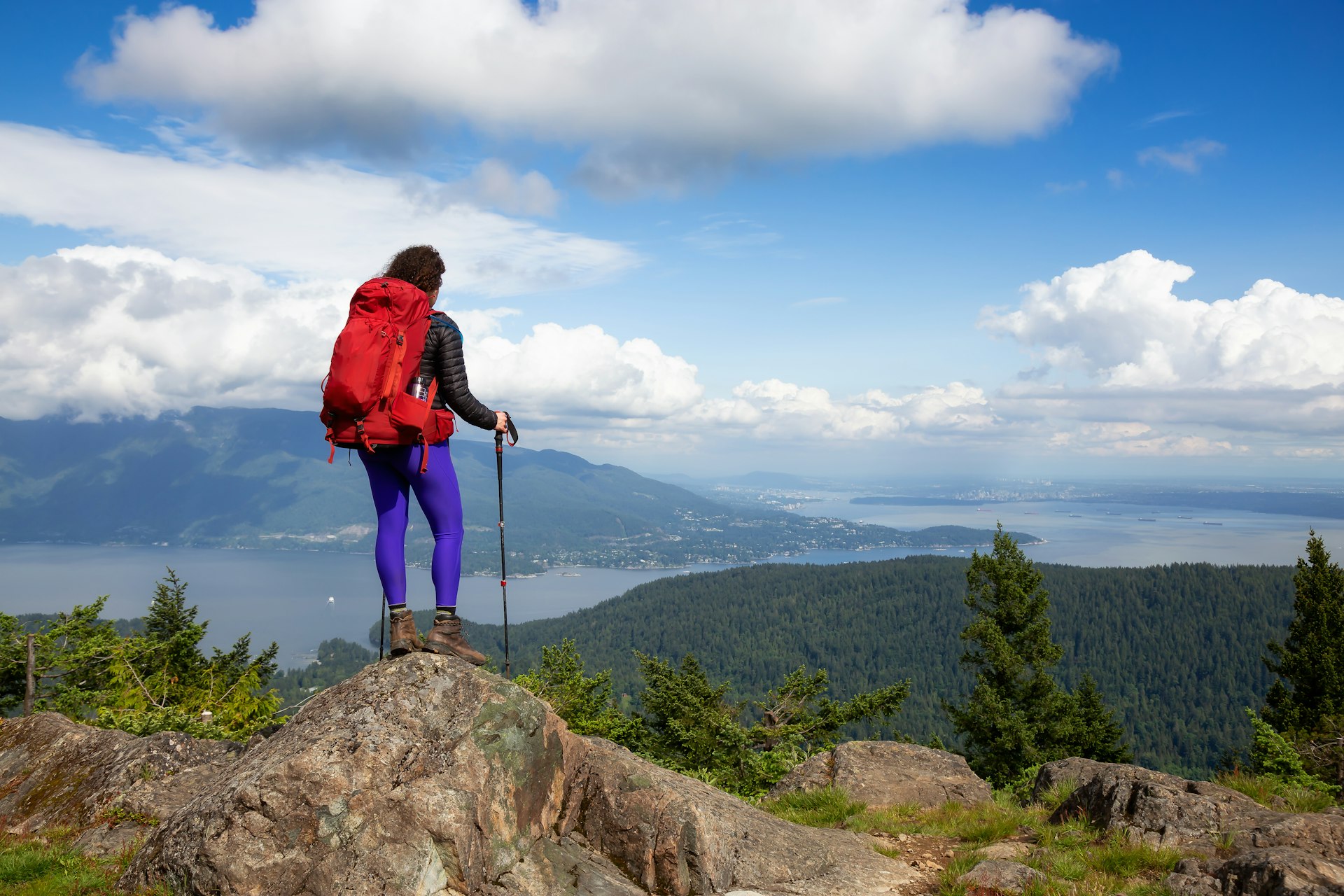 A hiker on a hilltop overlooking the water, Bowen Island, British Columbia, Canada