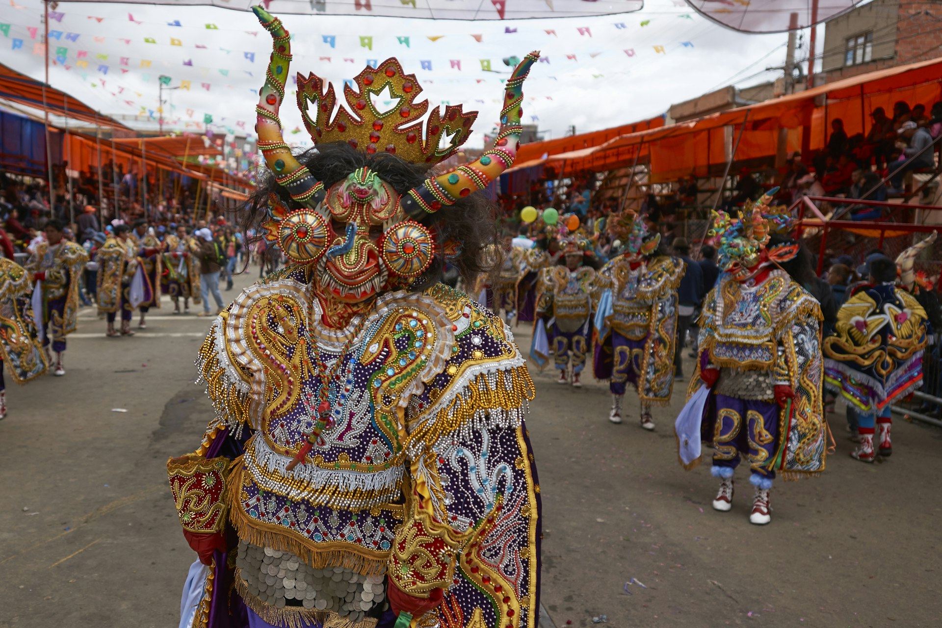 Diablada dancers in ornate costumes prepare to parade through the mining city of Oruro on the Altiplano of Bolivia during the annual carnival