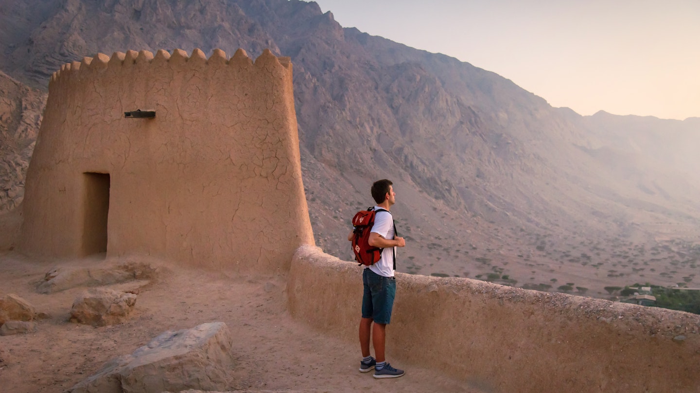 Man visiting middle eastern Dhayah Fort in north Ras Al Khaimah, United Arab Emirates on the desert mountain top at sunset. Caucasian man traveling to Middle East
1286976886