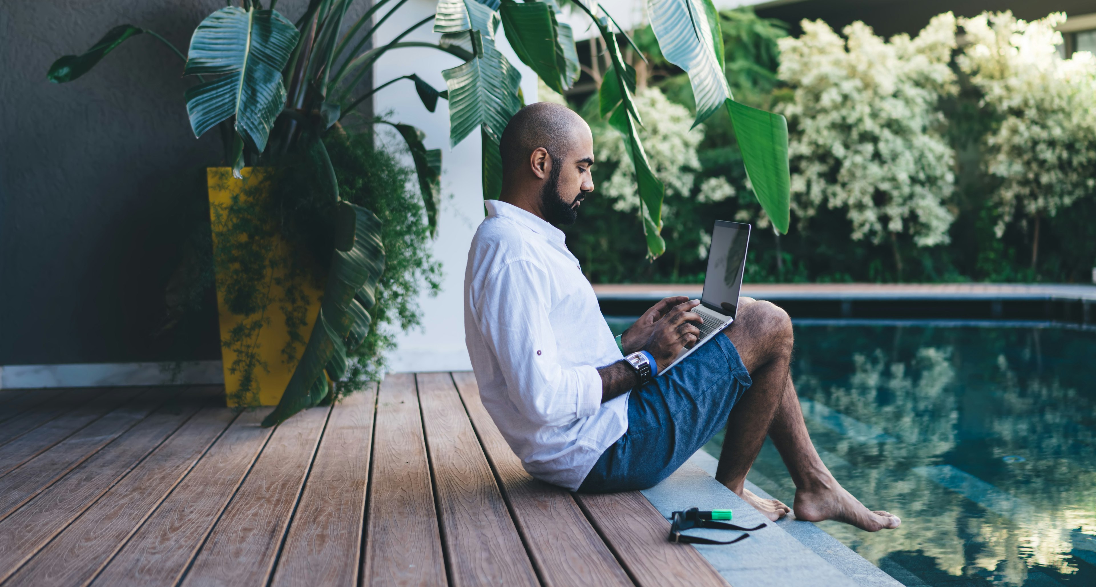 A remote worker using laptop by a pool in Bali, Indonesia