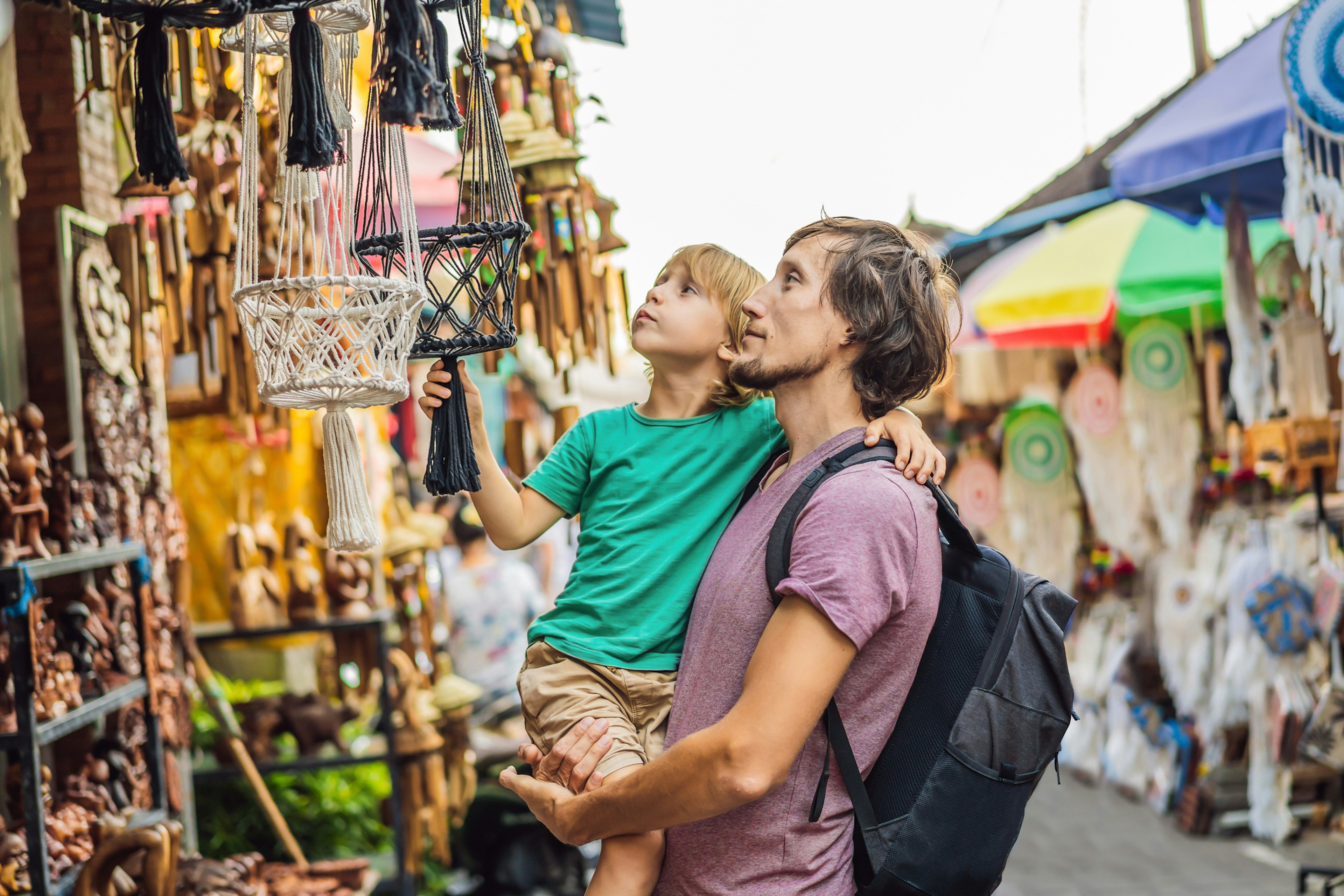 A father and son look at crafts in a market