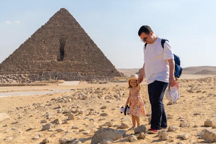 Father with daughter walking in front of the pyramid of Mikerin on the Giza plateau
1367244349
