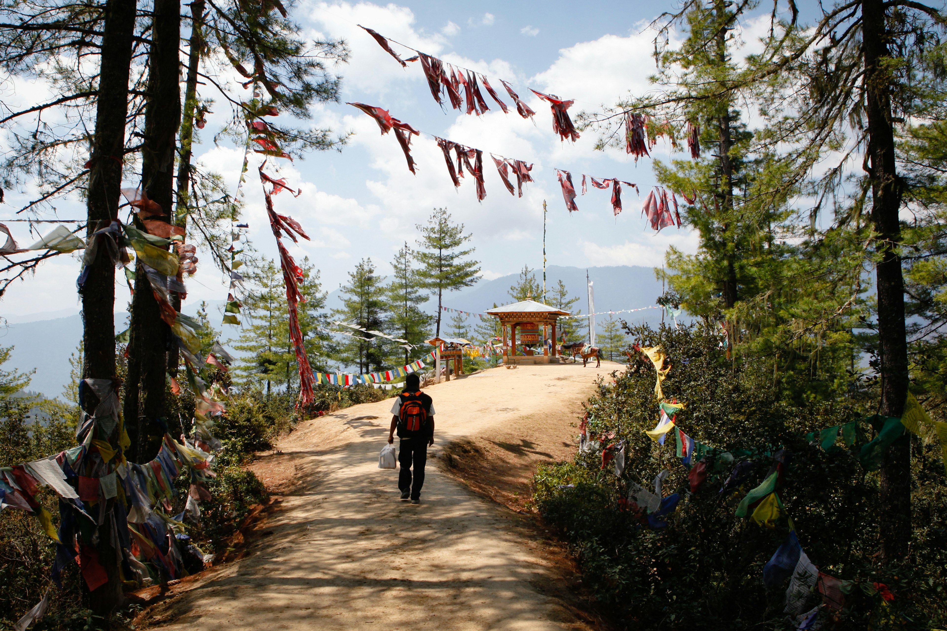 A hiker with a backpack on the trail to the Tiger's Nest Monastery in Bhutan.