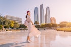 Experience the fusion of modernity and tradition as an Indian woman walks against the backdrop of Abu Dhabi's iconic skyscrapers.
1487672966
girl, walk, real, estate, destination, trip, indian, arab
A woman walking across a plaza outdoors in Abu Dhabi with high-rise buildings in the background