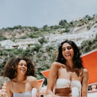 Two women laughing together on a beach on the Amalfi Coast