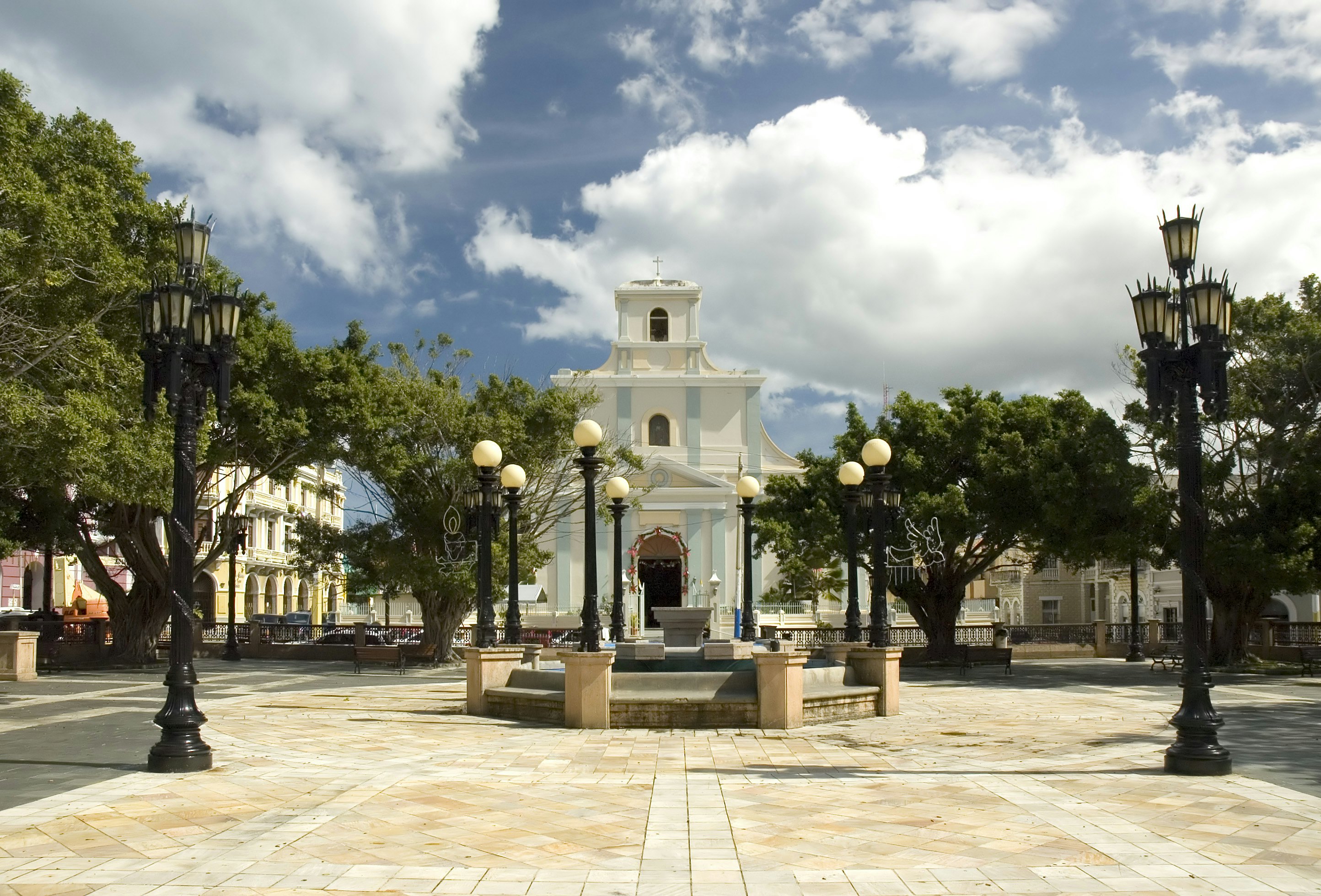 A public square and a white church with light blue accents in Puerto Rico.