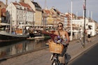 Happy young woman with sunglasses enjoying while riding bicycle on Nyhavn pier in city
1692796054