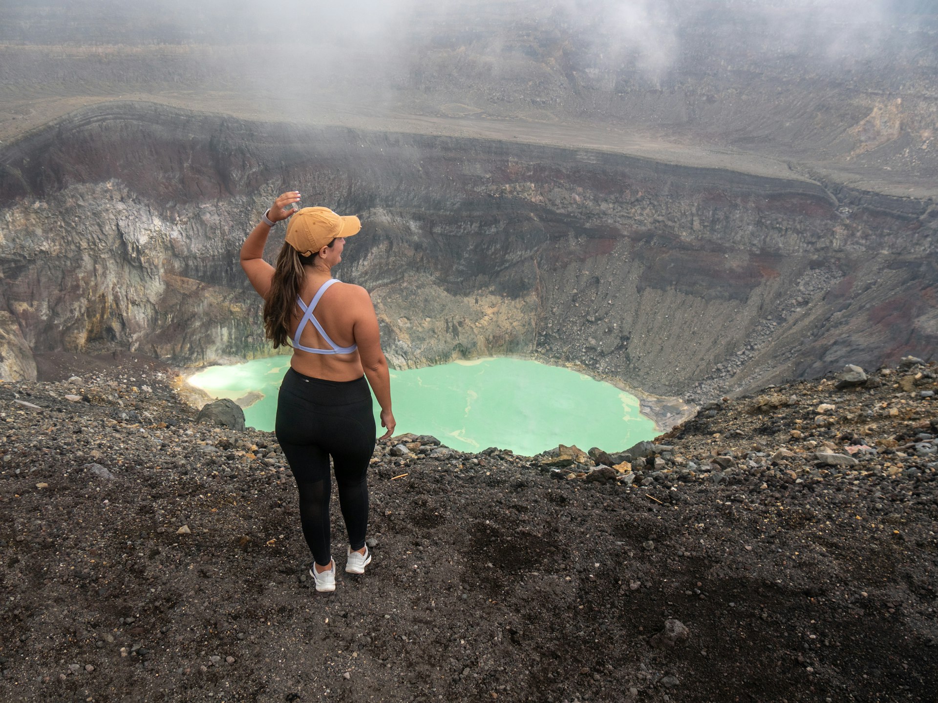 A woman looks down into the crater lake of Santa Ana Volcano, El Salvador